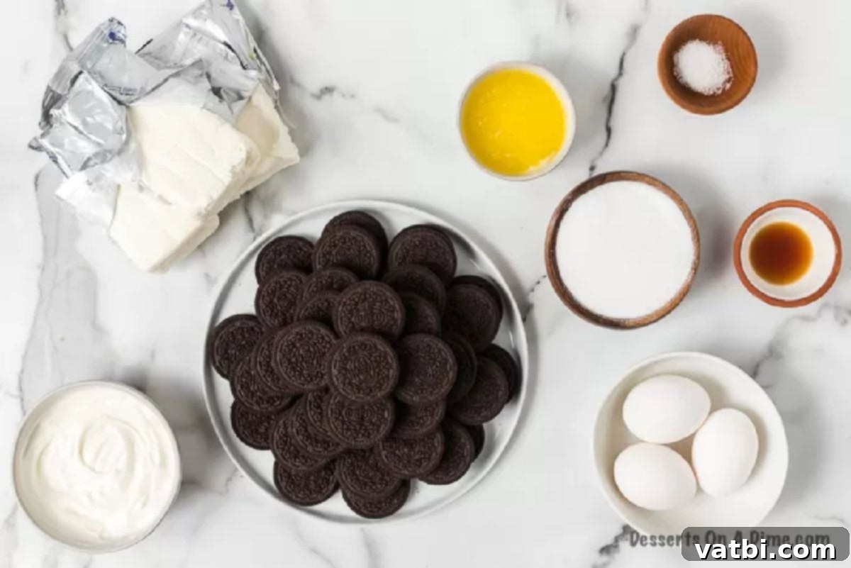 Irresistible Oreo Cheesecake Delight 3 A flat lay photograph of all the ingredients needed to make Oreo Cheesecake Bars, including packages of Oreo cookies, blocks of cream cheese, a stick of butter, sugar, sour cream, and eggs.