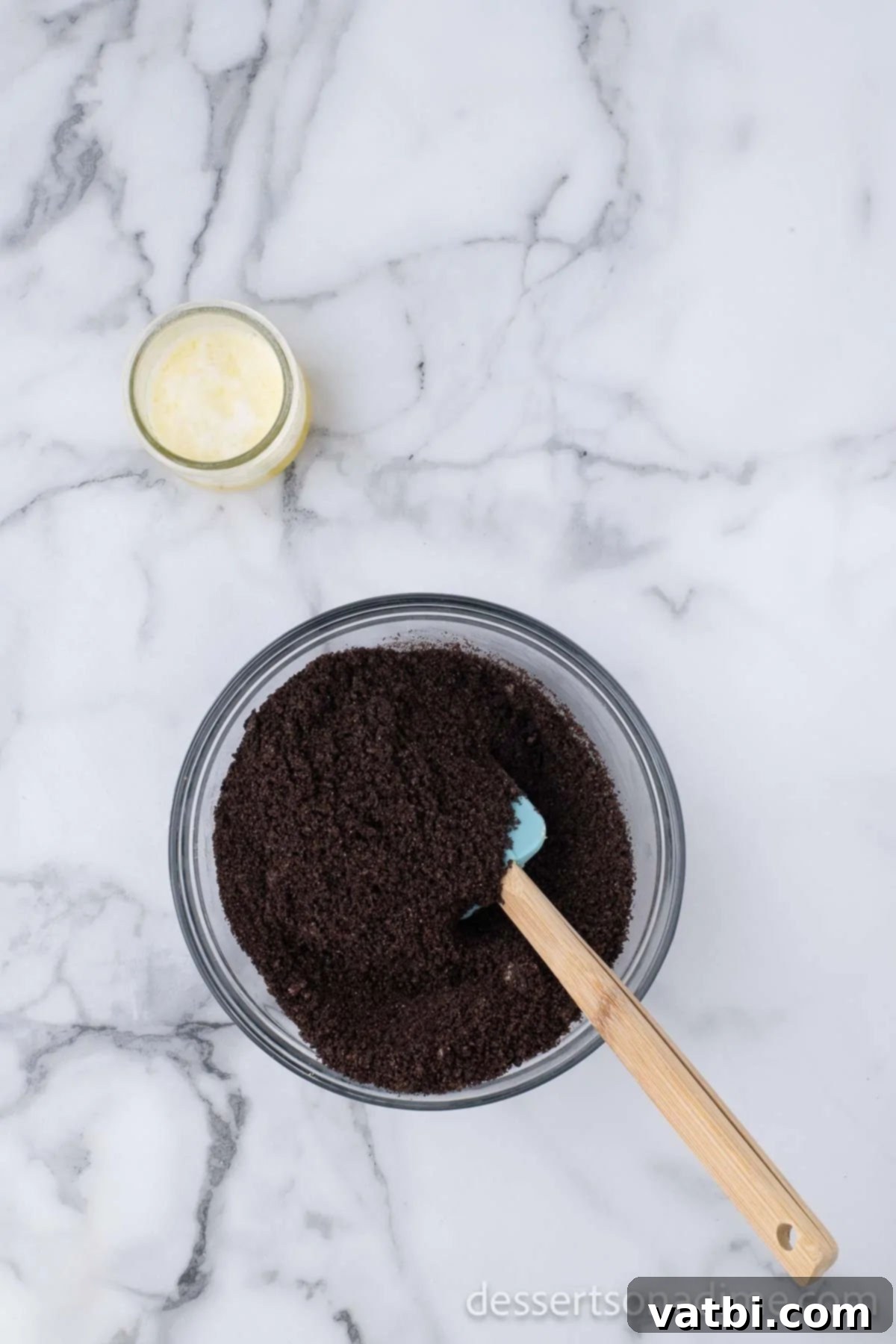 Irresistible Oreo Cheesecake Delight 5 Finely crushed Oreo cookies mixed with melted butter in a bowl, ready for the crust.