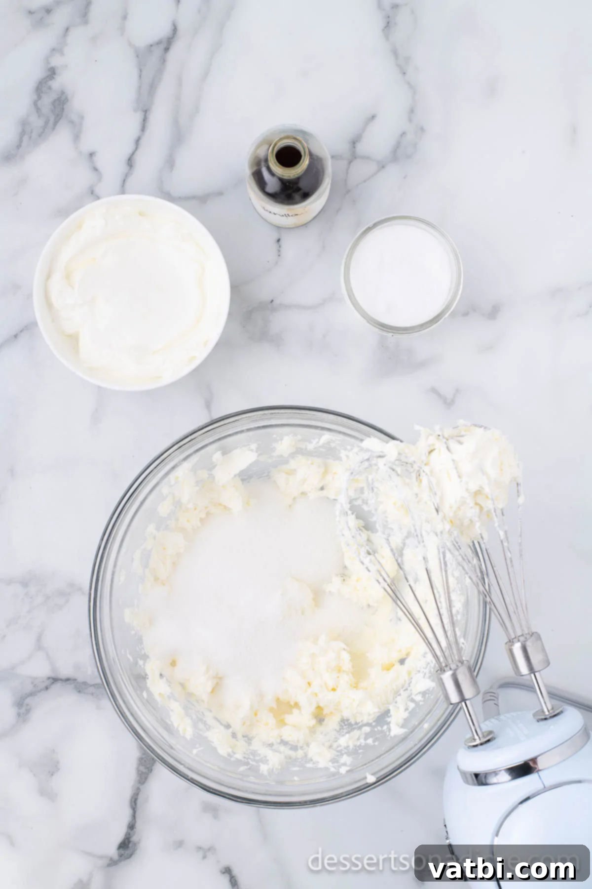 Irresistible Oreo Cheesecake Delight 8 Granulated sugar being added to the creamy cream cheese mixture in a mixing bowl.