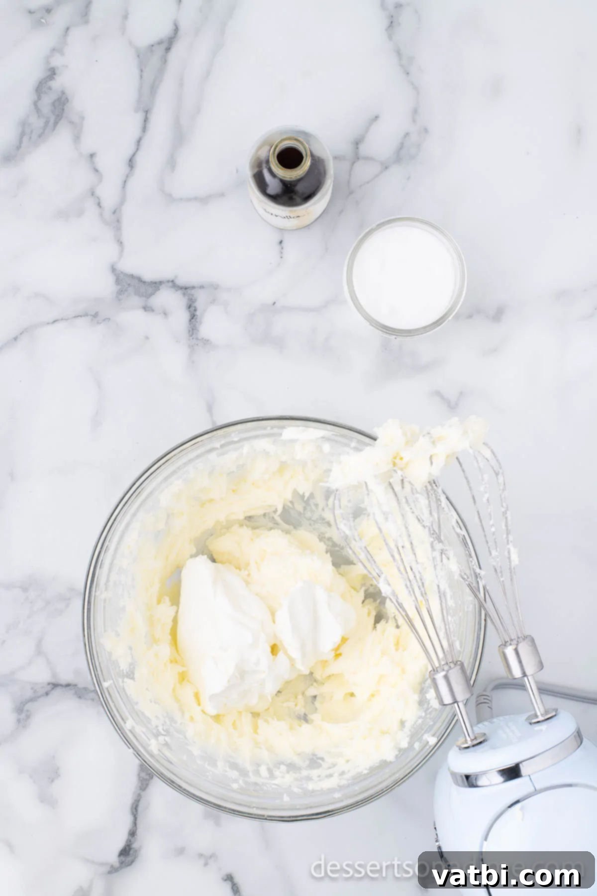 Irresistible Oreo Cheesecake Delight 9 Sour cream being added to the cheesecake mixture in a large bowl.