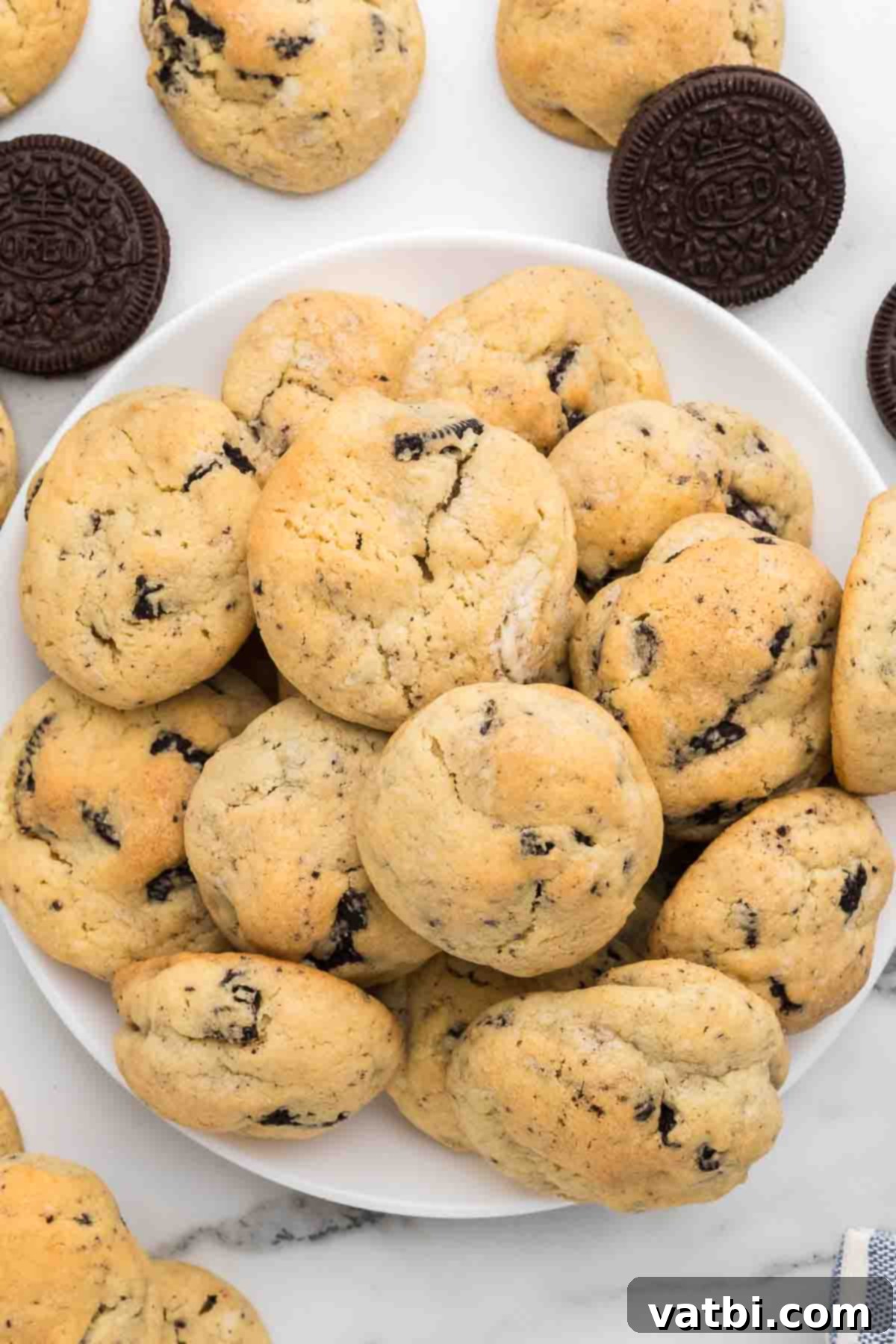 Skip the mixes and make this decadent recipe for Cookies and cream cookies. Each bite is loaded with oreo cookies and the recipe is so easy. Try this cookies and cream cookies recipe without pudding for the best treat. Learn how to make home made desserts with chocolate oreo cookies and cream cheese. #dessertonadime #cookiesandcreamcookies #cookiesandcreamcookieseasy #dough #DIY #DessertRecipes #Recipeshomemade #baking #dessert #christmas #homemade Close up image of Cookies and Cream Cookies stacked on a platter