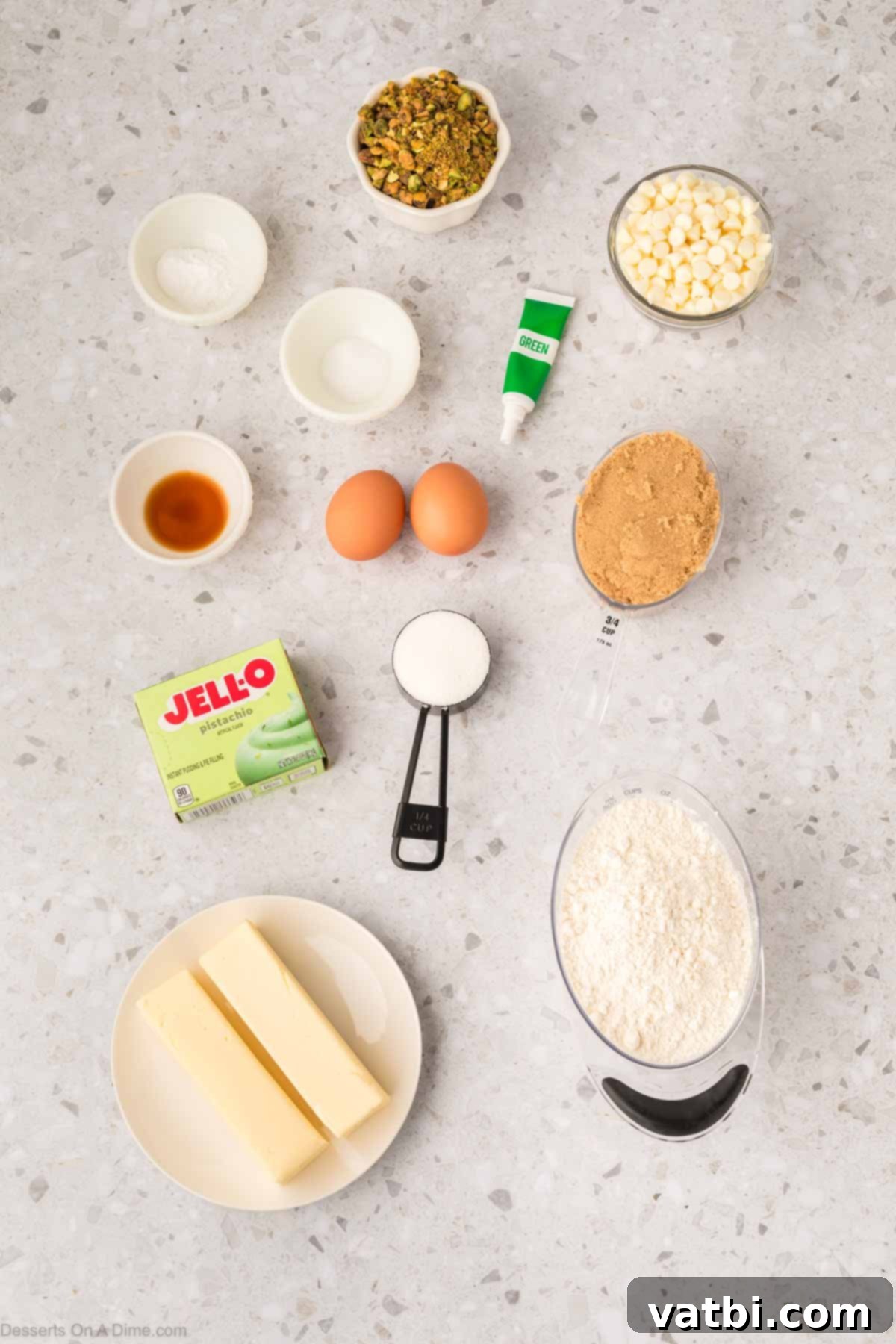 Emerald Kiss Cookies 3 Ingredients for making delicious pistachio cookies, including brown sugar, white sugar, eggs, pistachio pudding mix, vanilla extract, all-purpose flour, green food coloring, white chocolate chips, and crushed pistachios.