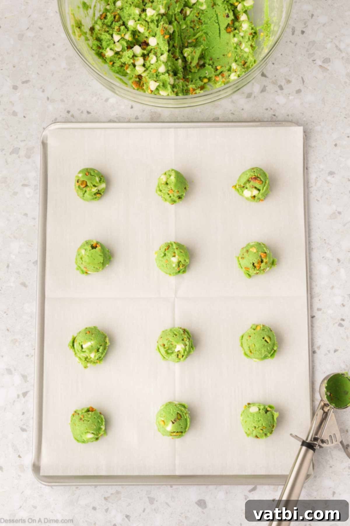 Emerald Kiss Cookies 10 Scooped cookie dough balls placed on a parchment-lined baking sheet.