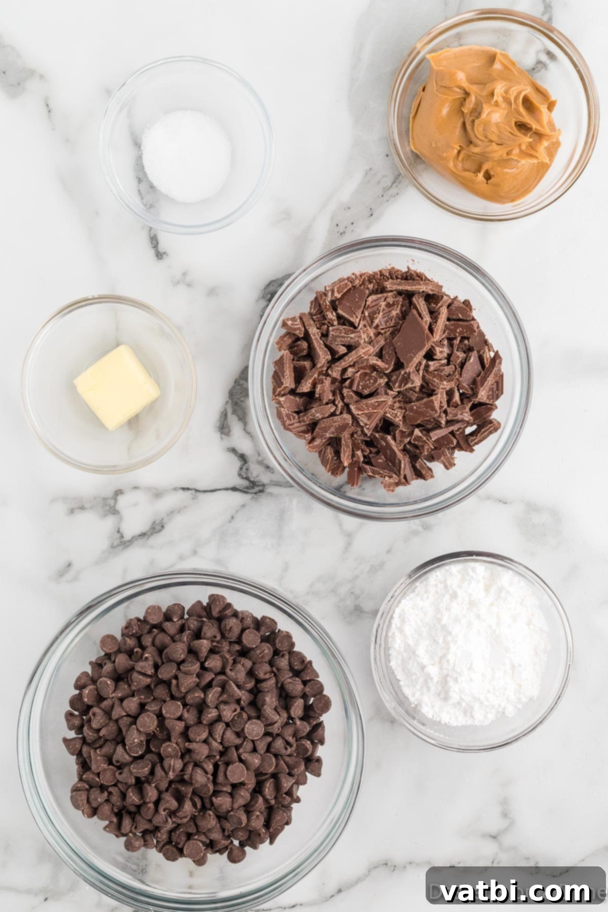 Decadent Homemade Peanut Butter Cups 3 All the necessary ingredients for peanut butter cups: creamy peanut butter, unsalted butter, powdered sugar, salt, chocolate chips, and chocolate candy bars, neatly arranged.