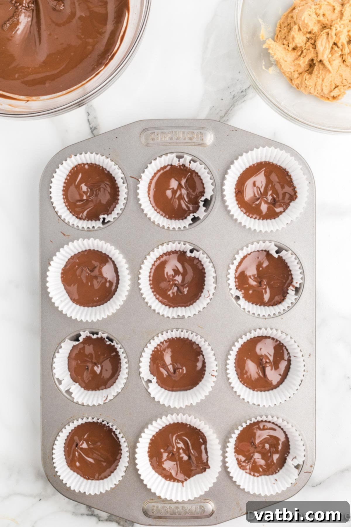 Decadent Homemade Peanut Butter Cups 7 Melted chocolate mixture being carefully divided into paper cupcake liners arranged in a muffin tin.