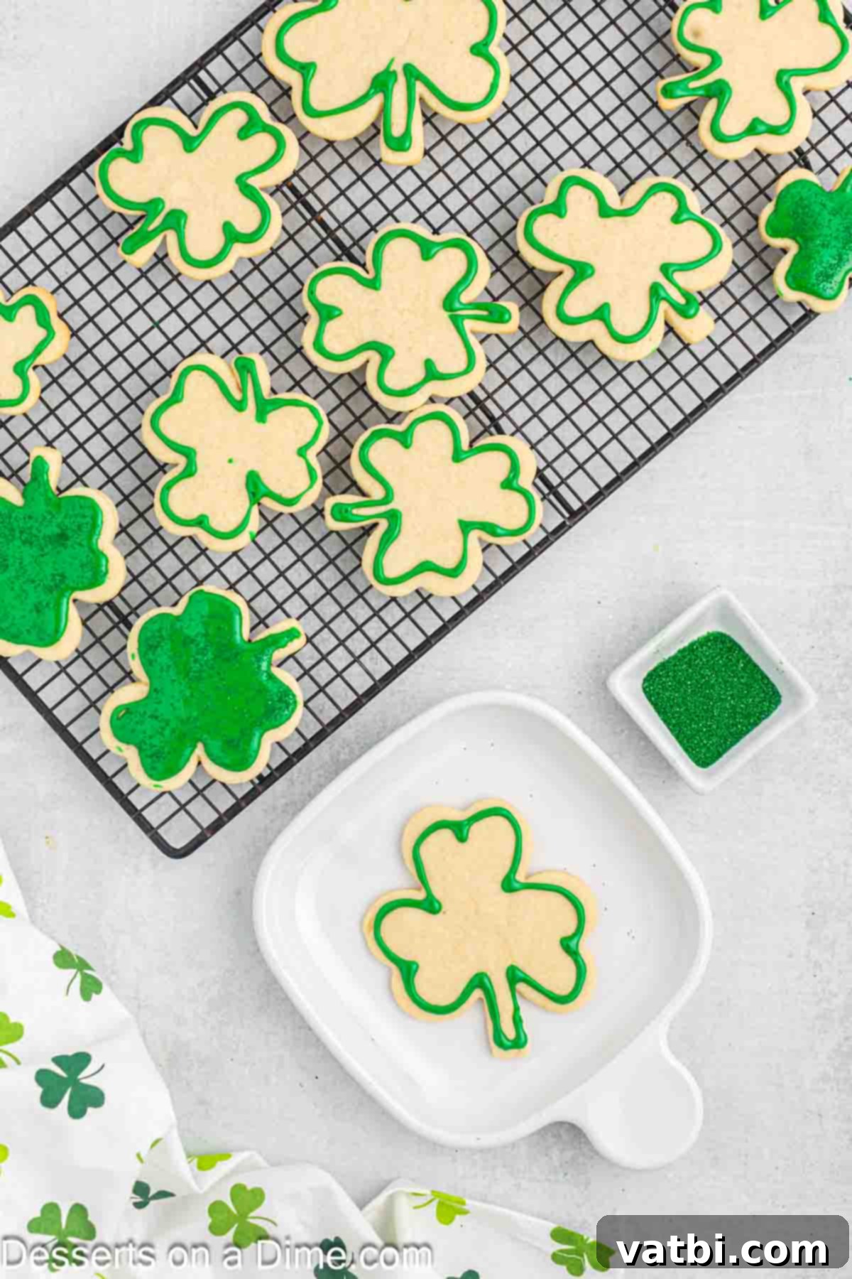 Sweet Clover Delights 13 Green frosting being meticulously piped onto a shamrock cookie using a piping bag with a decorative tip, creating a neat outline and fill.