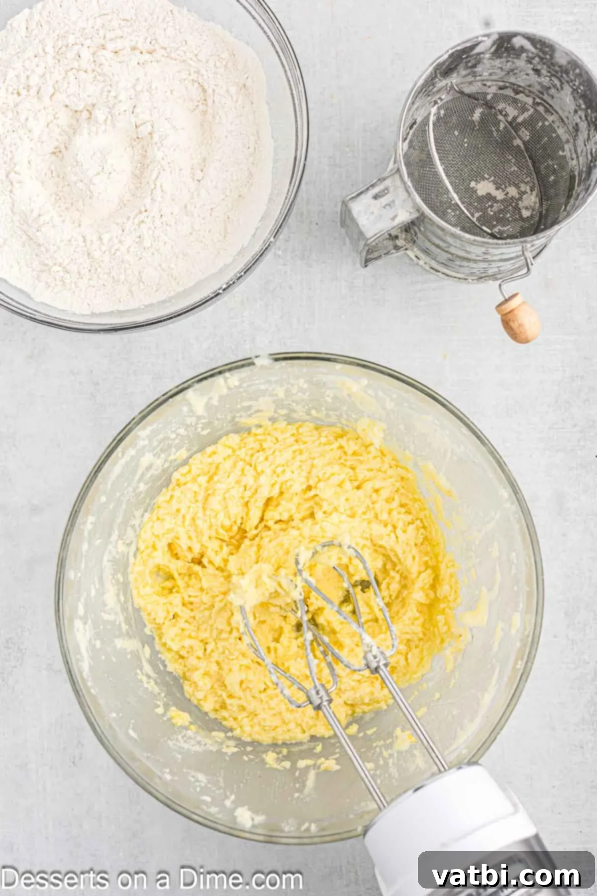 Sweet Clover Delights 5 Large eggs and vanilla extract being added to the creamed butter and sugar mixture in a mixing bowl, prior to full incorporation.