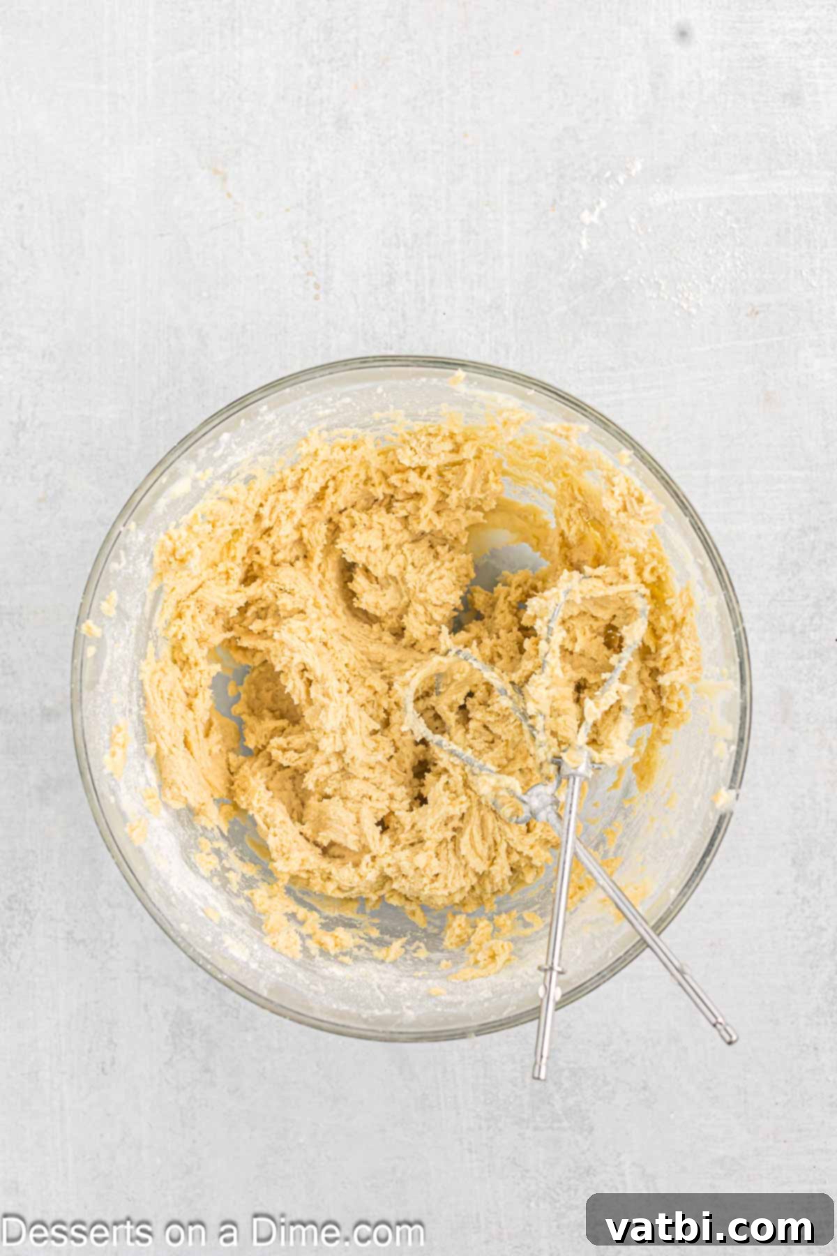 Sweet Clover Delights 6 Dry ingredients, including flour, baking powder, and salt, being added to the wet mixture in a bowl, ready to be combined into cookie dough.