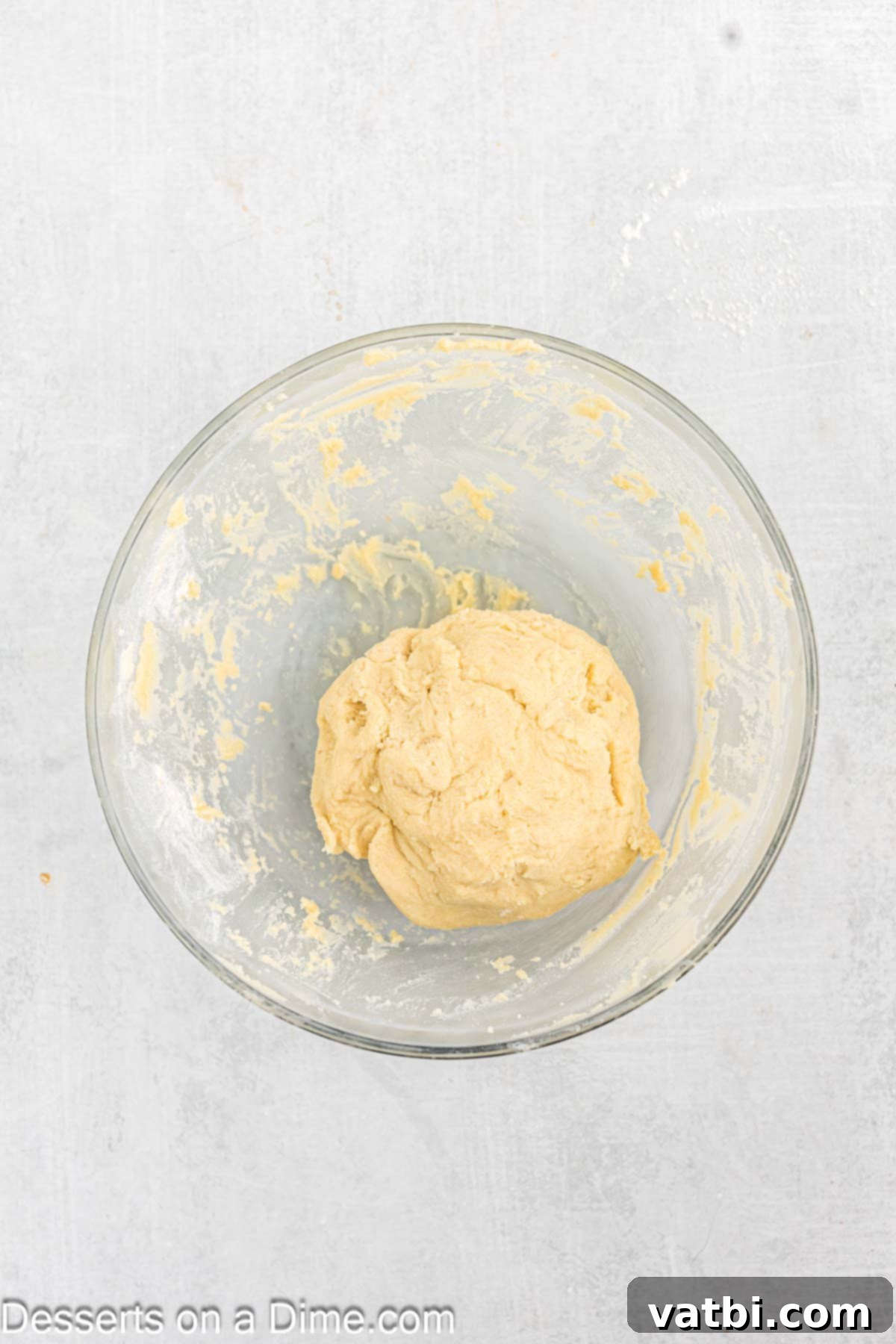 Sweet Clover Delights 7 Smooth cookie dough formed into a ball and placed in a bowl, ready to be wrapped for chilling.