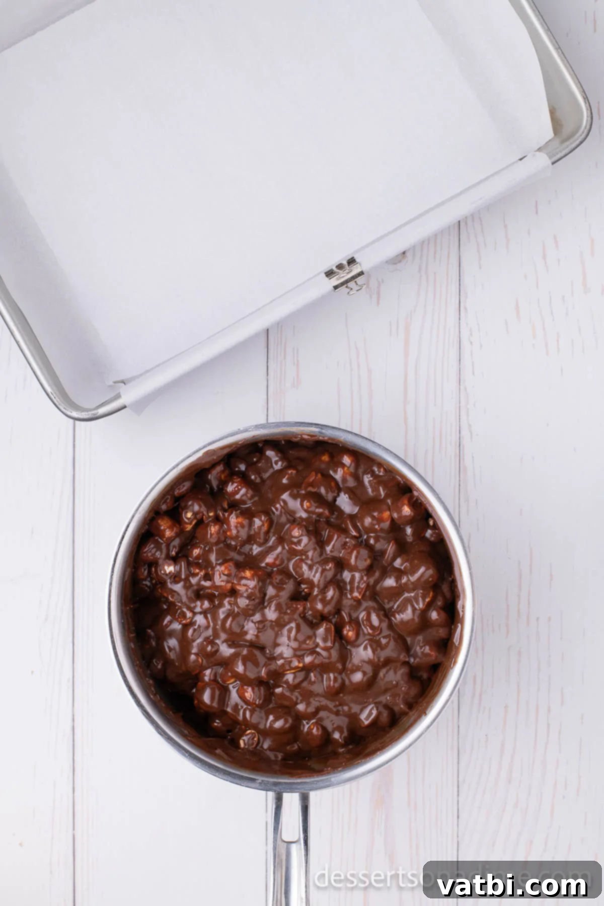 Decadent Rocky Road 5 The melted chocolate mixture in a pan, slightly cooled, with dry roasted peanuts added and ready to be stirred.