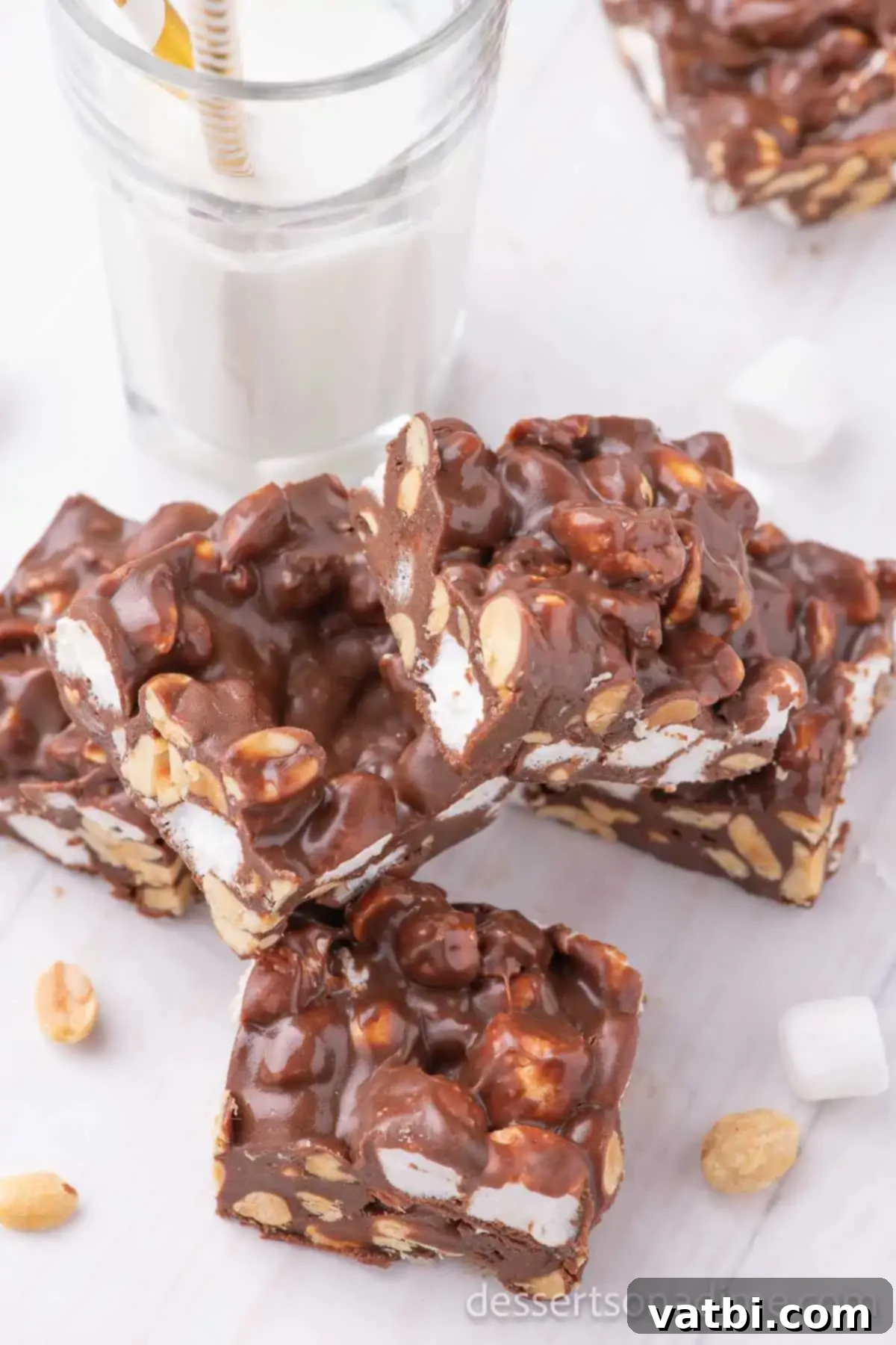 Decadent Rocky Road 8 Numerous perfectly cut squares of Rocky Road Candy, stacked artfully, showcasing their rich chocolate, fluffy marshmallow, and crunchy peanut texture.