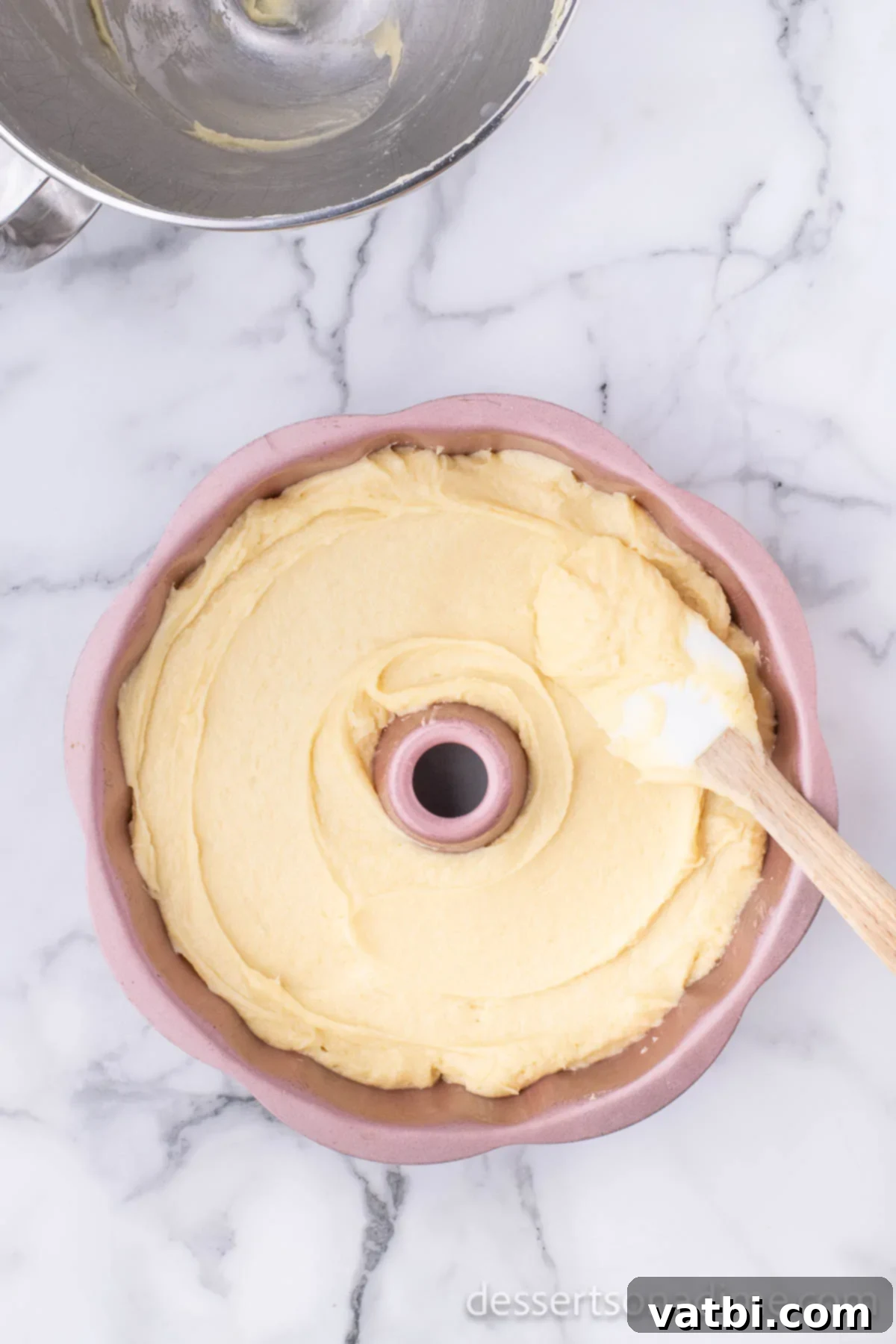 Effortless Pound Cake Perfection 7 Smooth pound cake batter being carefully poured and spread into a prepared Bundt cake pan.