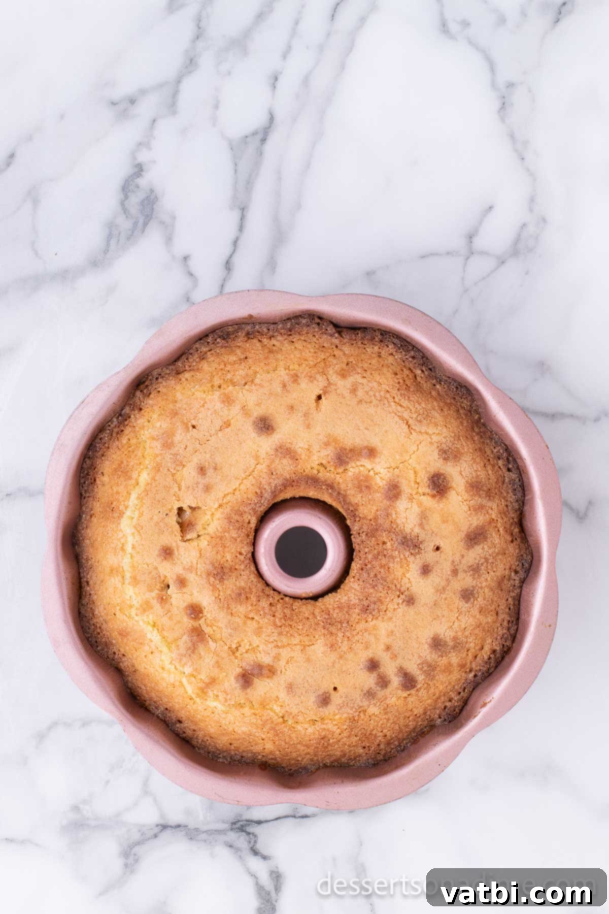 Effortless Pound Cake Perfection 8 Golden brown pound cake cooling in its Bundt pan after baking, showcasing its perfect rise.