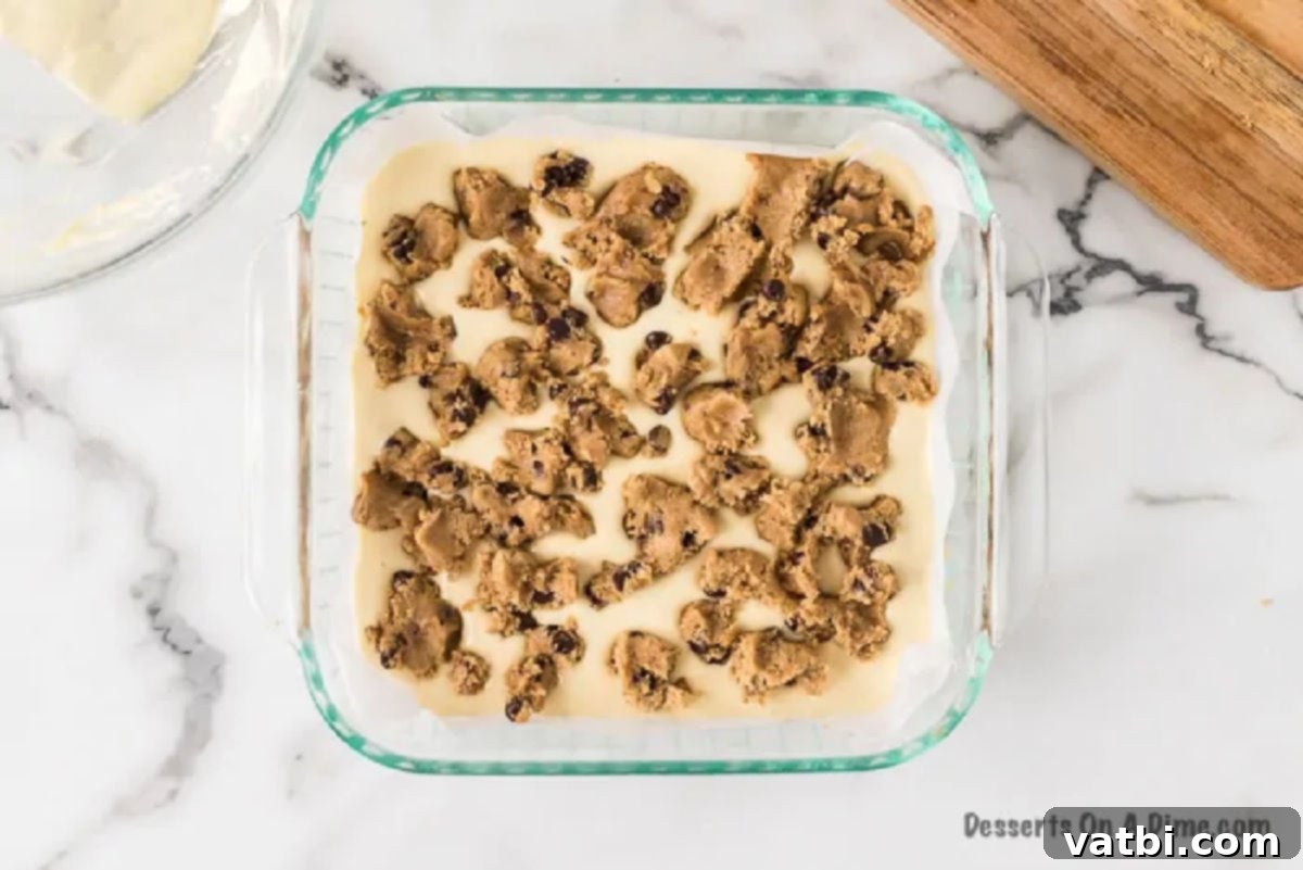 Remaining cookie dough crumbled over the cheesecake layer, creating a top crust.
