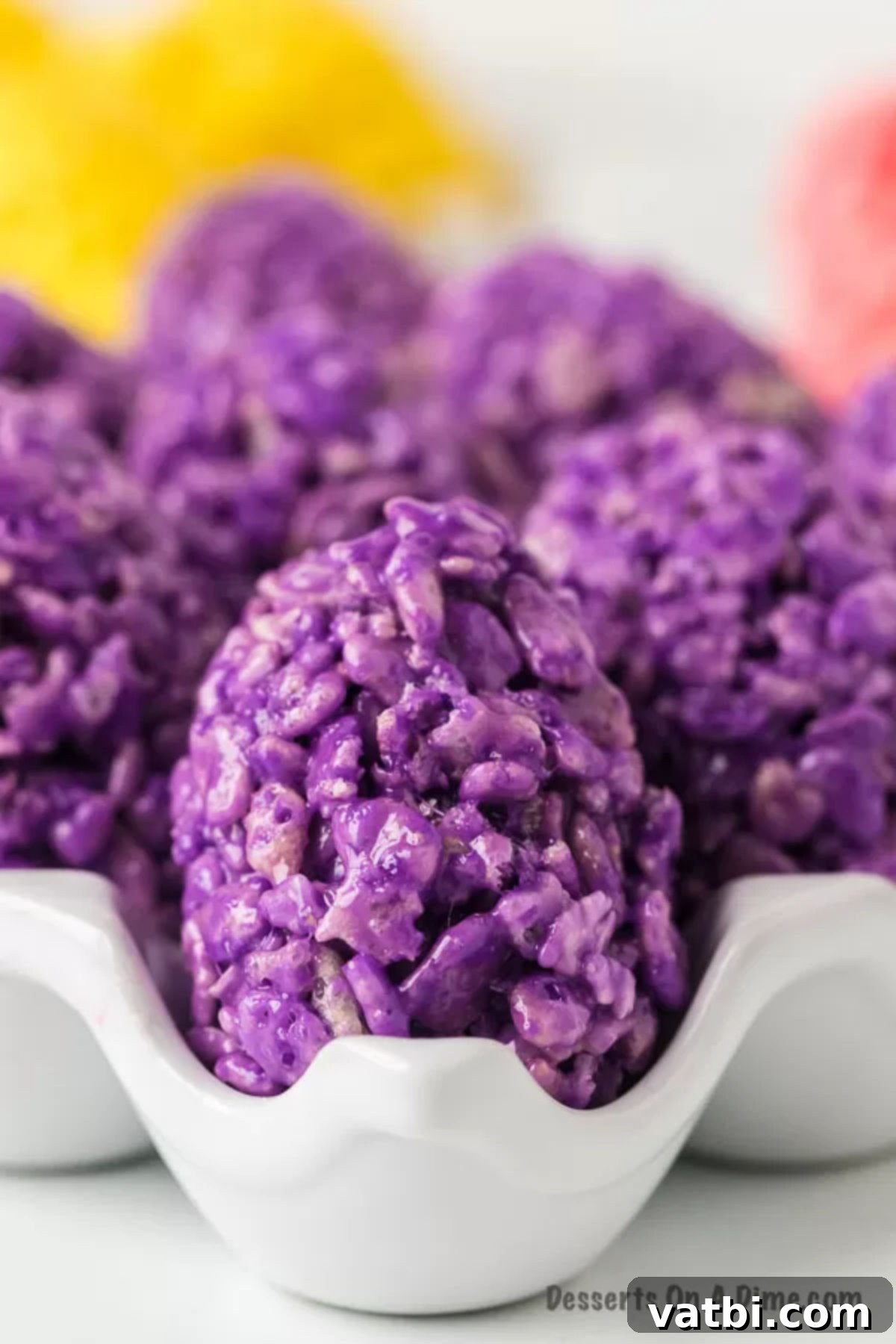 Decorated Easter Egg Rice Krispie Treats ready to enjoy. Assortment of decorated Rice Krispie Easter Egg Treats in a white egg carton, some with sprinkles