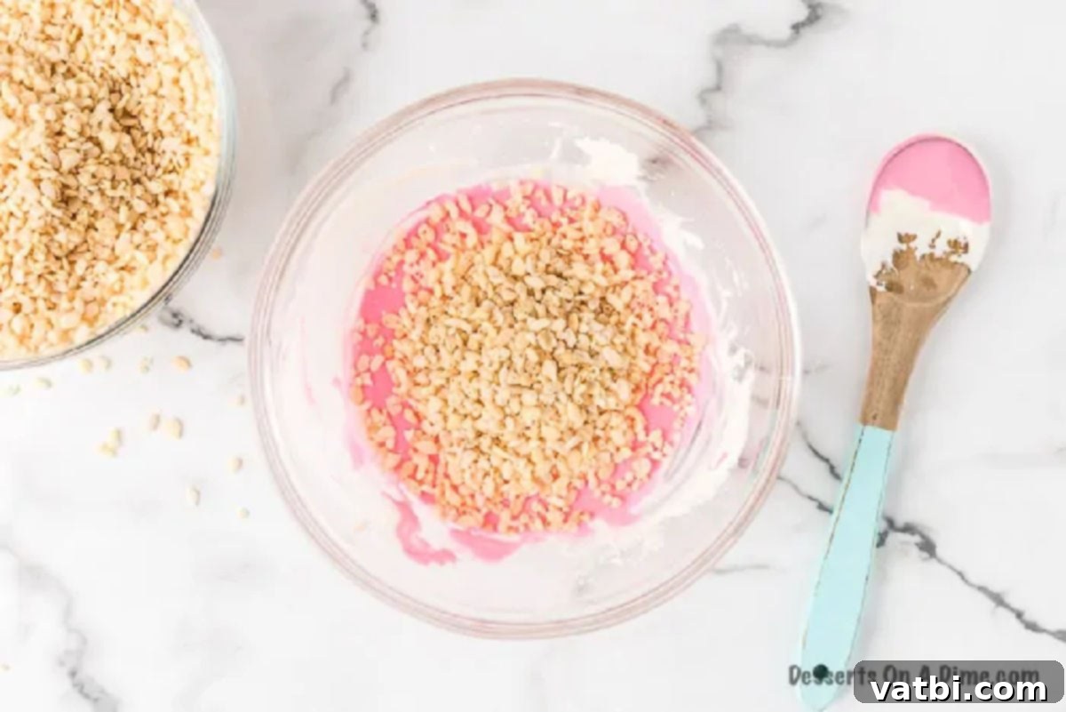 Colorful Easter Krispie Eggs 4 Rice Krispies cereal being folded into the pink marshmallow mixture until well combined