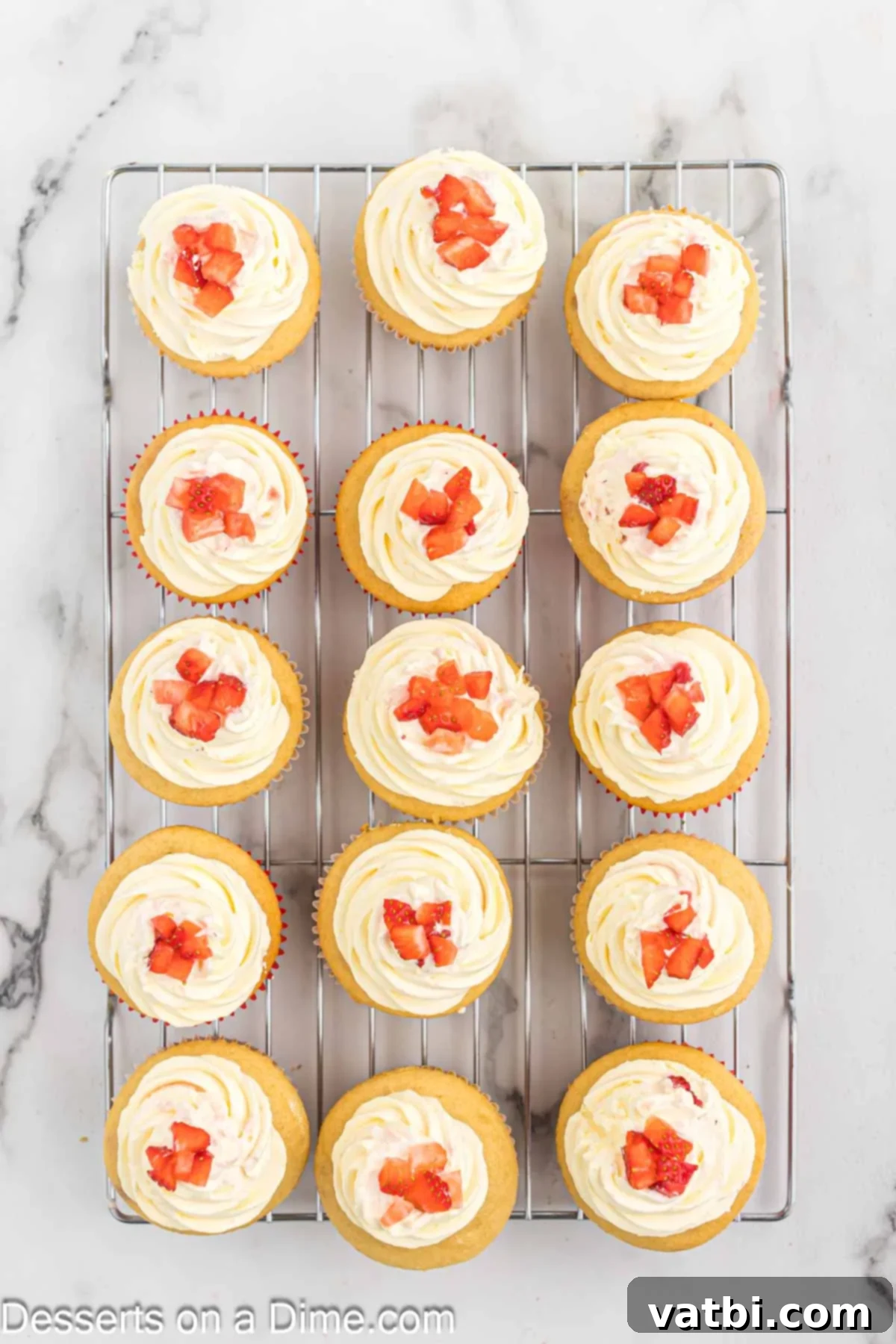 Heavenly Strawberry Shortcake Cupcakes 11 Finished Strawberry Shortcake Cupcakes topped with frosting and fresh strawberry pieces.