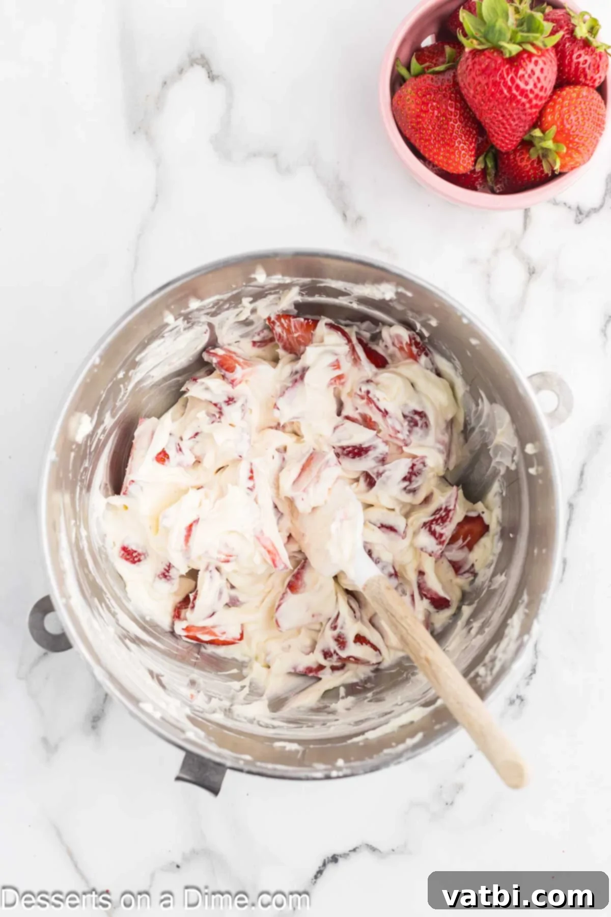Easy Strawberry Crunch Bars 9 Sliced strawberries being gently folded into the cream cheese and whipped cream mixture.