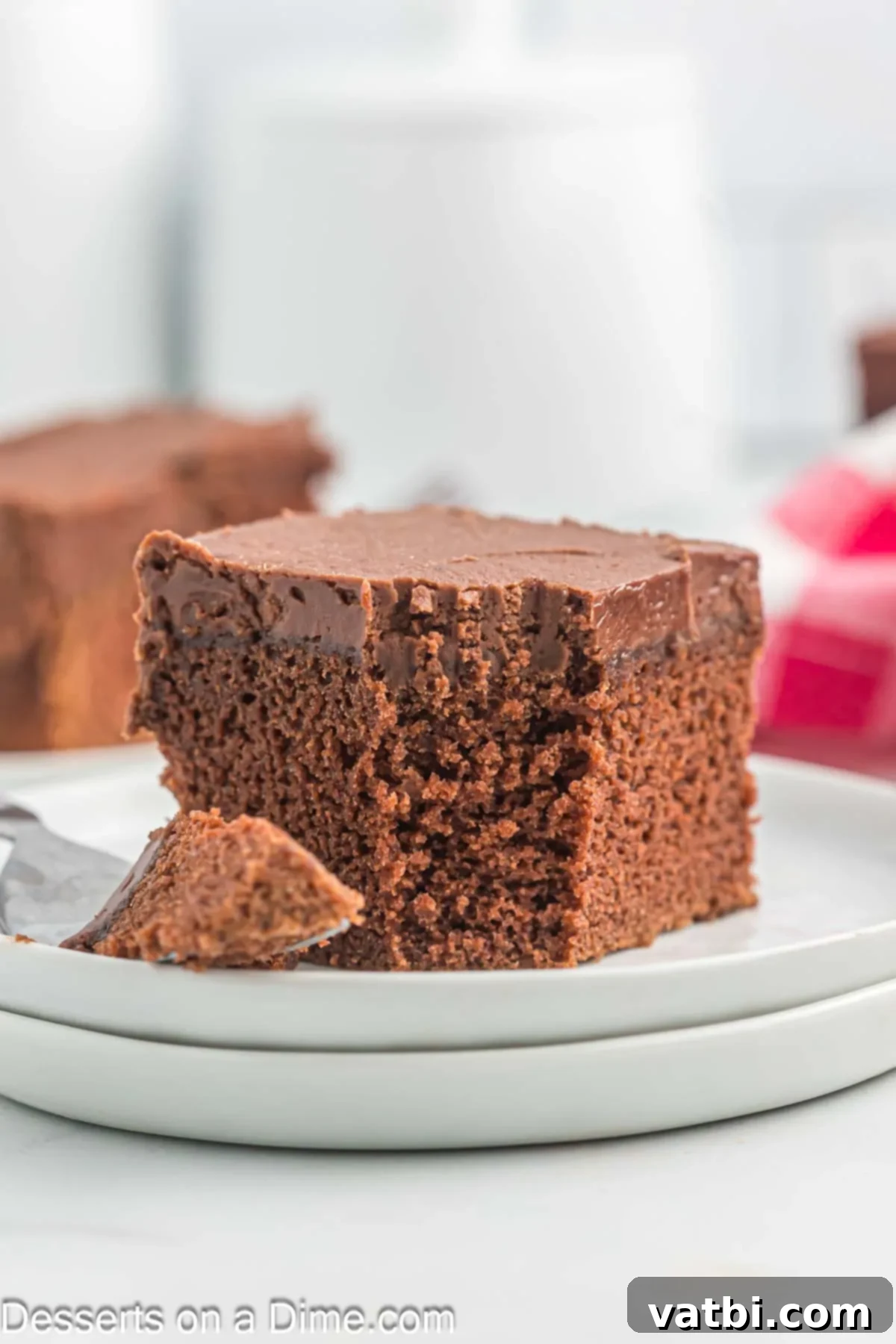 Effortless Chocolate Delight 2 A slice of moist chocolate cake with chocolate frosting on a plate, ready to be enjoyed.
