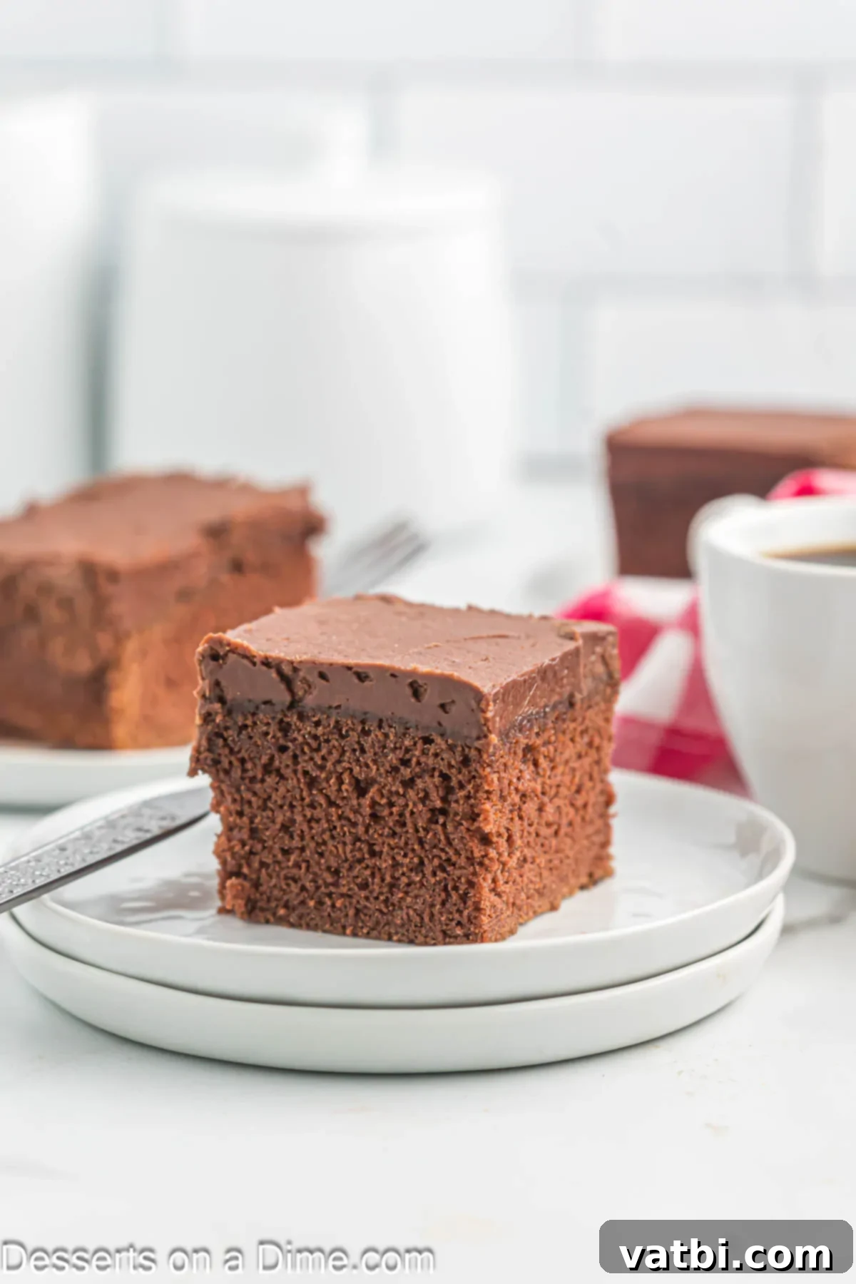 Effortless Chocolate Delight 11 A generous slice of chocolate cake with frosting on a white plate.