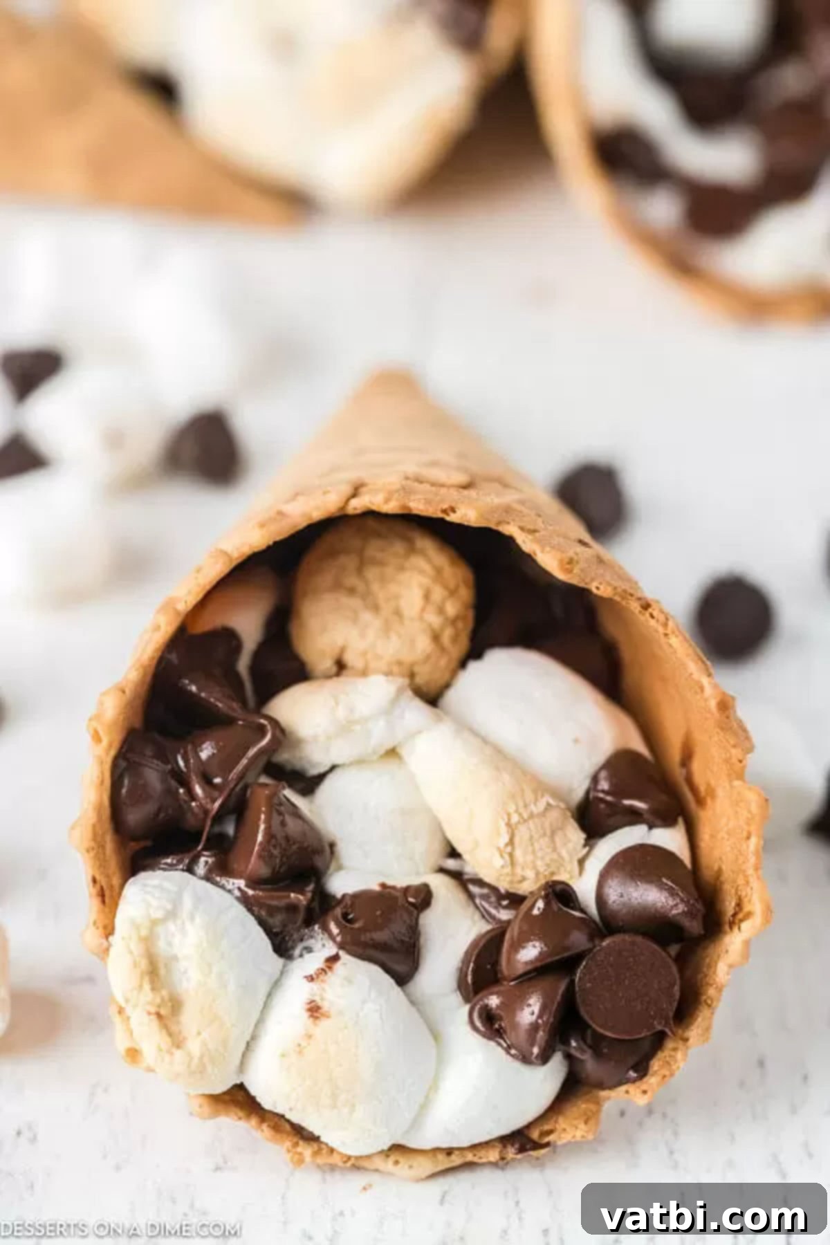 Smores Cones are so fun to eat with yummy chocolate and marshmallows. These waffle cone smores combine all that you love into a handy cone. Smores cones filled with chocolate chips and marshmallows, ready to be cooked and enjoyed.