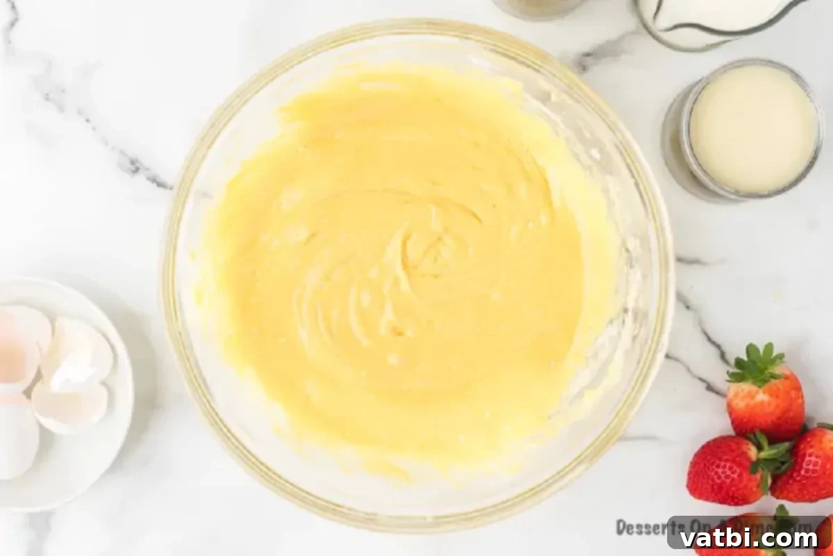 Mixing bowl with cake batter ingredients before whisking.