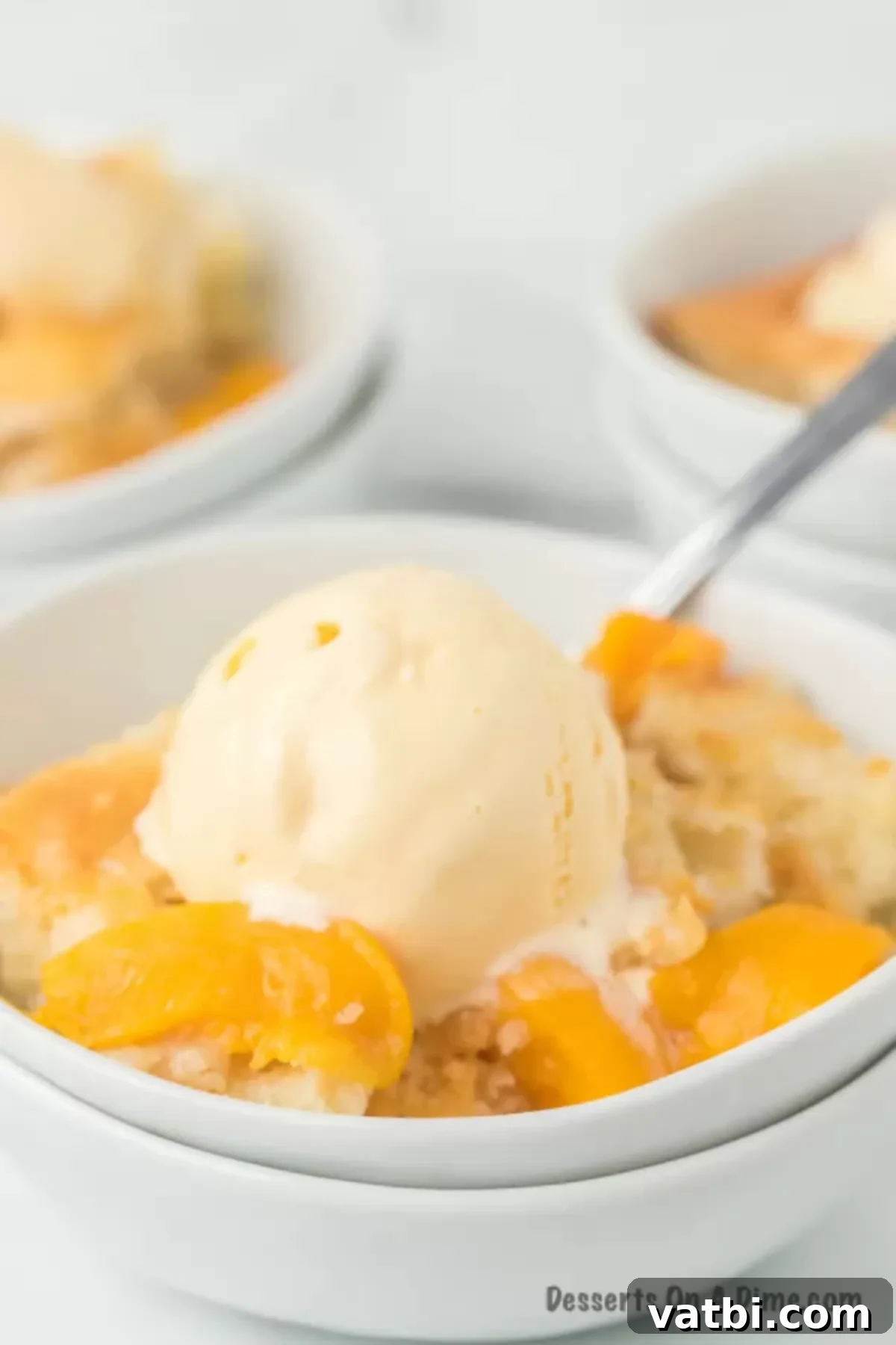 This old fashioned peach cobbler is the best recipe and you likely already have all the ingredients to make this today. Just add ice cream. Bowl of warm peach cobbler generously topped with melting vanilla ice cream, ready to be enjoyed.