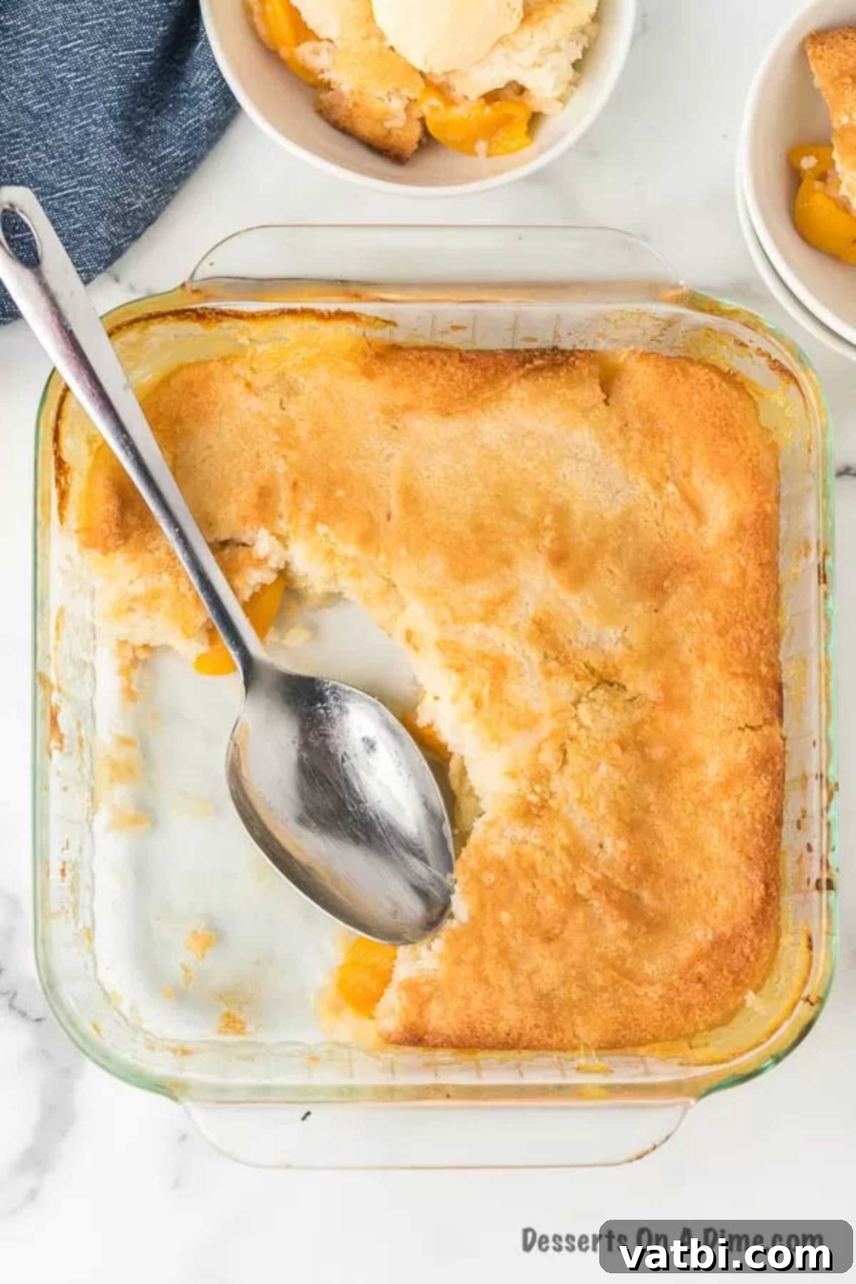 Deliciously Simple Peach Cobbler 2 Unbaked peach cobbler in a glass baking dish, ready for the oven, with a layer of peaches over batter.