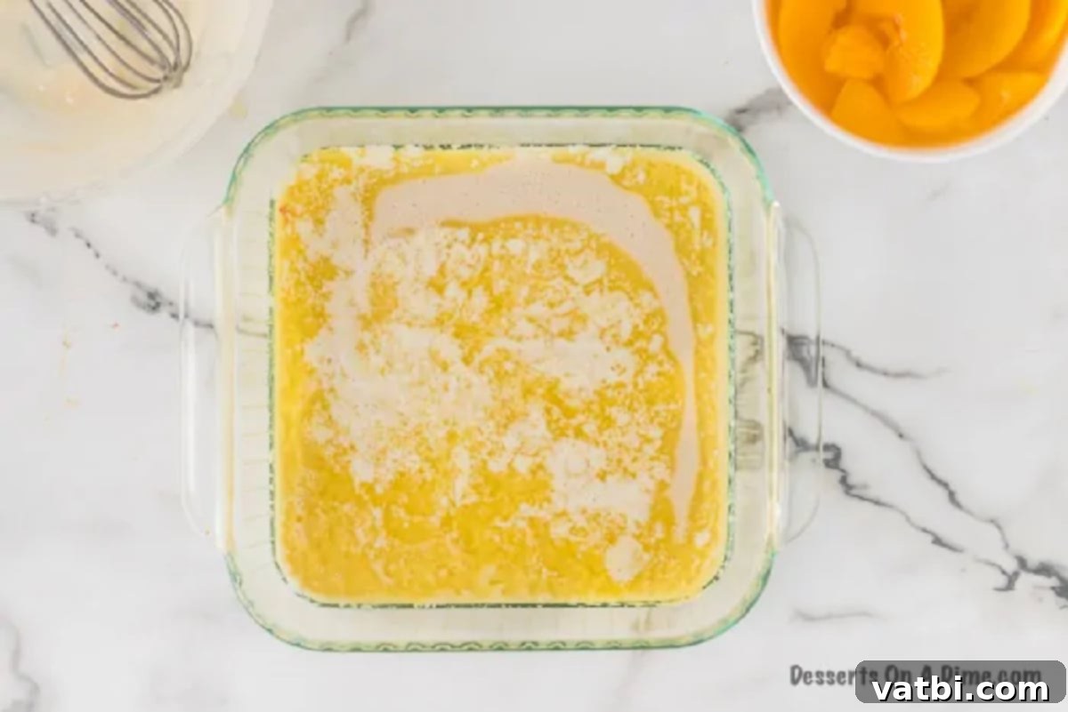 Deliciously Simple Peach Cobbler 6 Smooth cobbler batter being poured carefully over the melted butter in the baking dish, creating distinct layers.