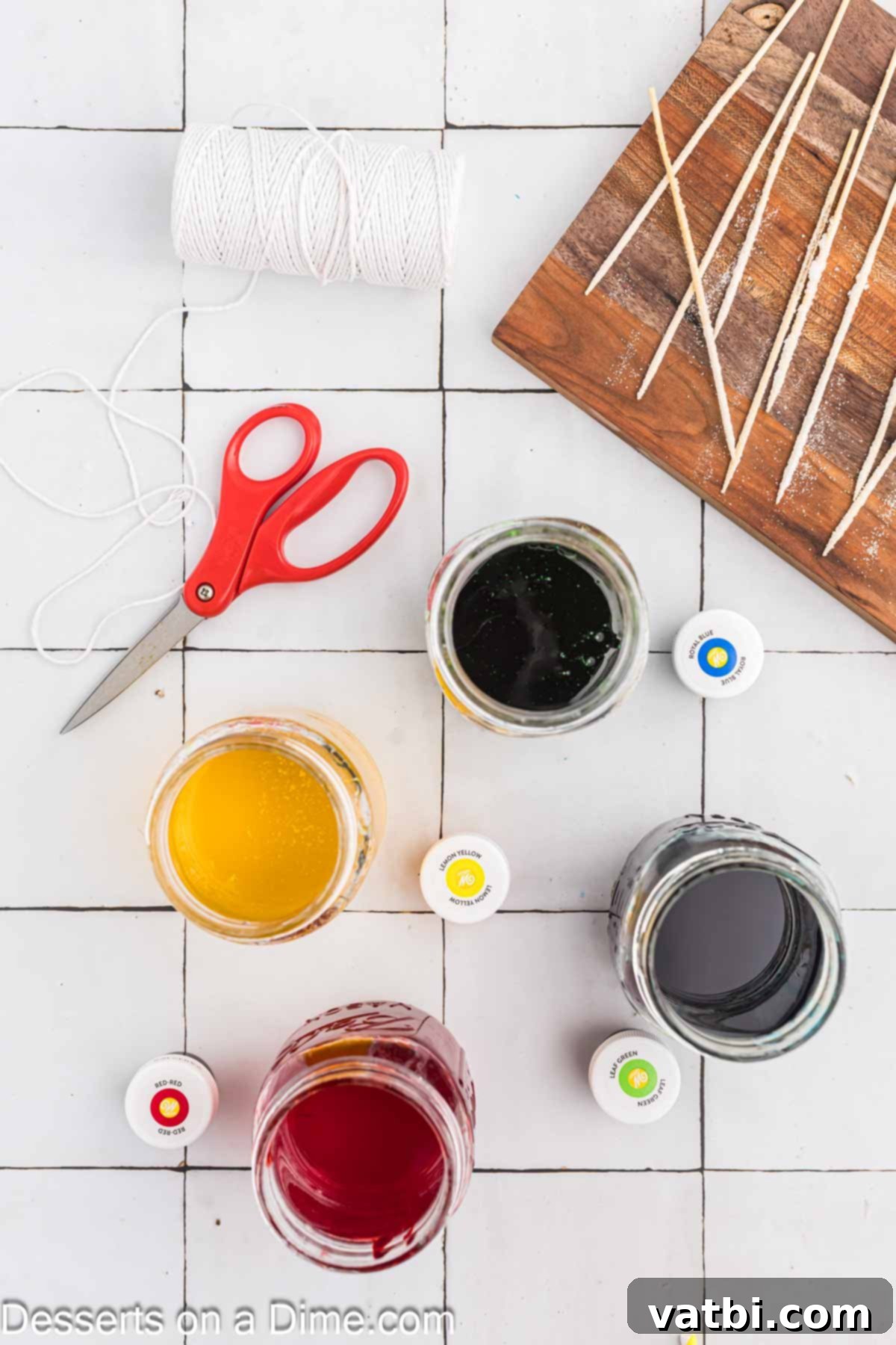 Grow Your Own Rock Candy Crystals 8 Food coloring being added drop by drop to the cooled sugar mixture in glass jars.