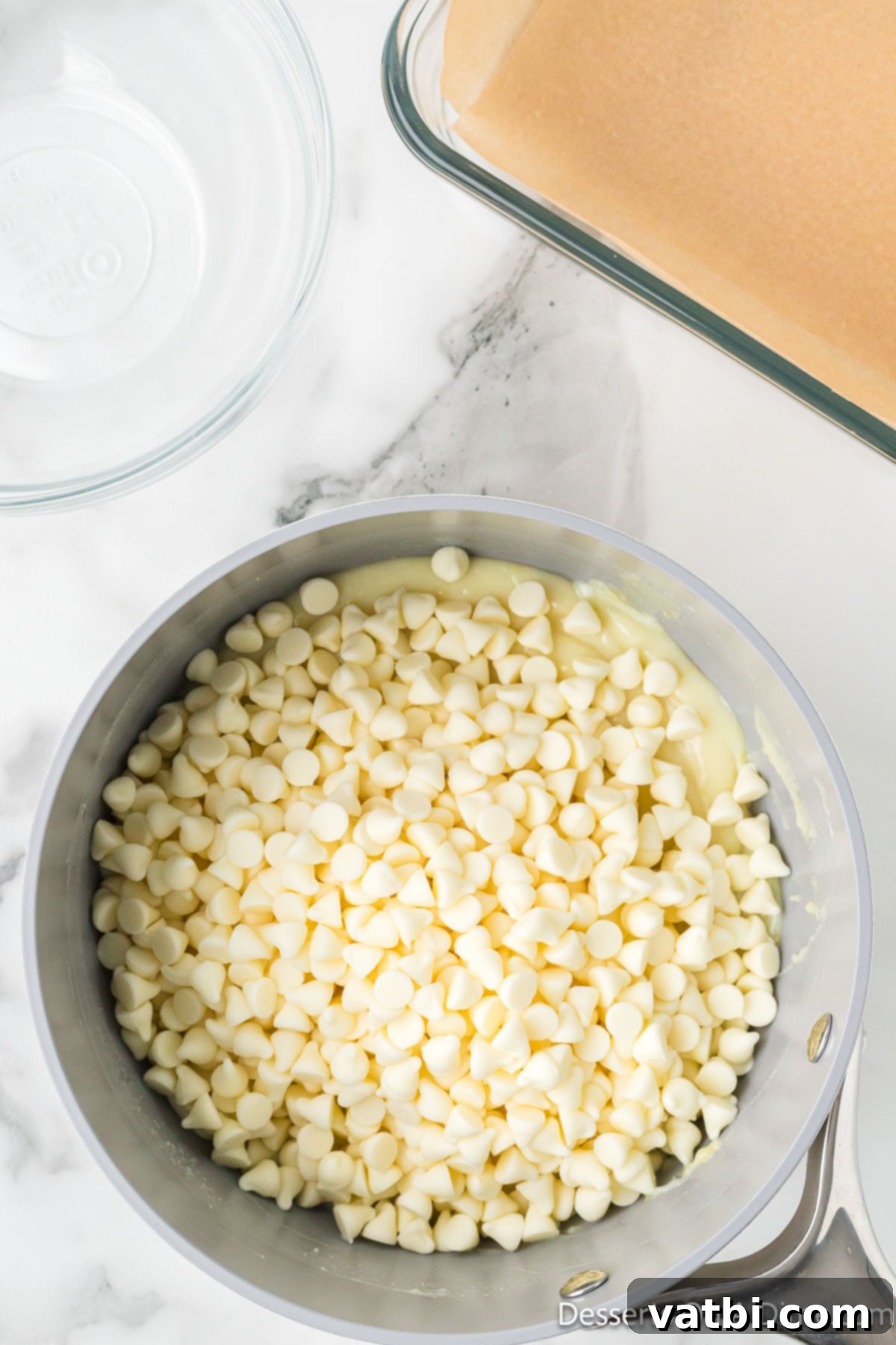 White chocolate chips added to the warm lemon mixture in the saucepan. 