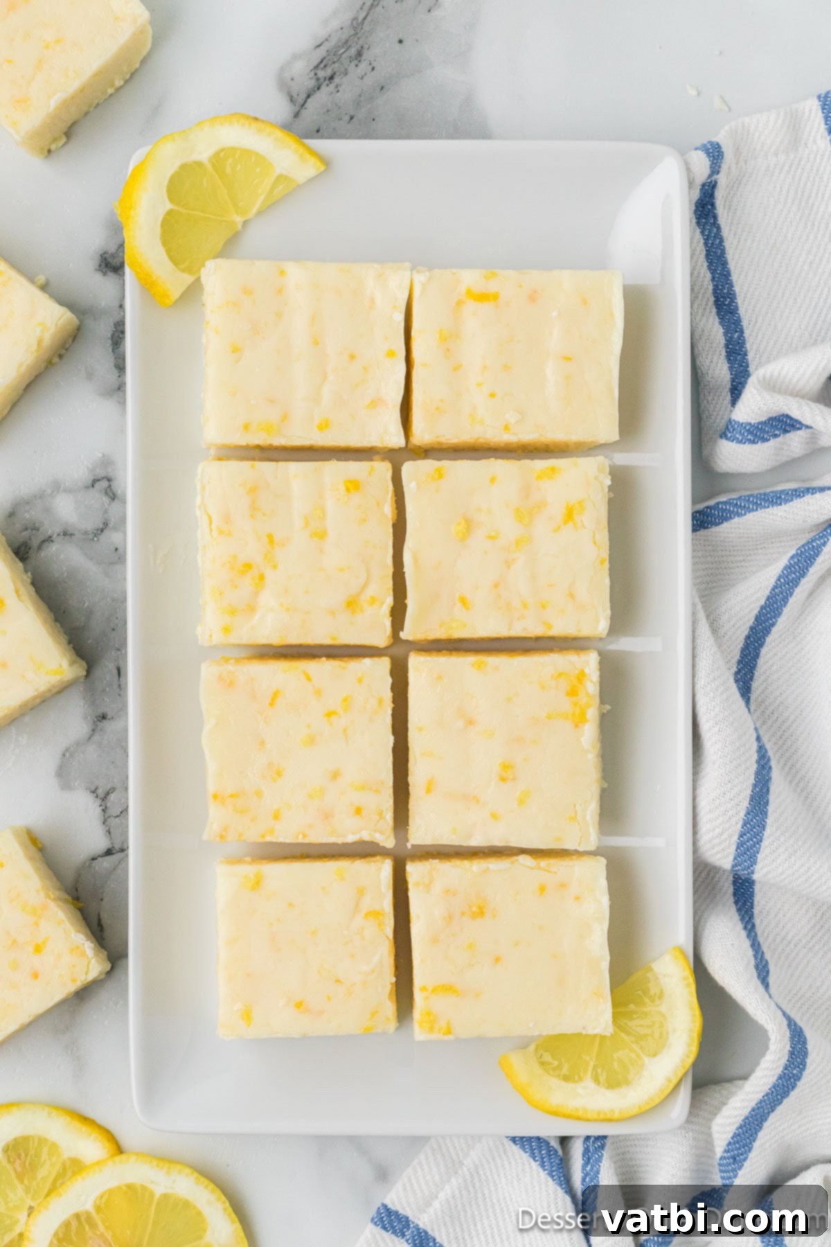 A platter of beautifully cut lemon fudge squares, garnished with a few sprigs of mint, ready for serving. 