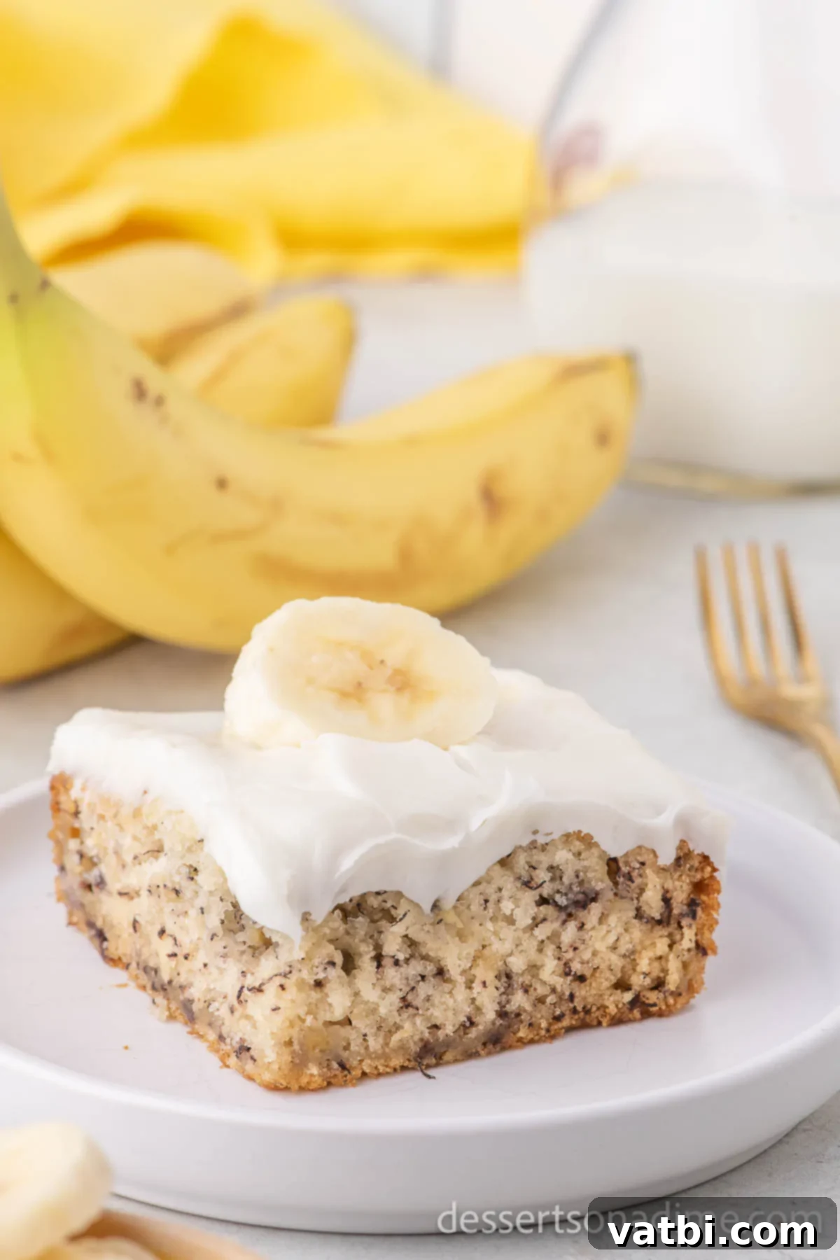 Wildly Delicious Banana Cake 2 A delectable slice of Crazy Banana Cake, perfectly moist and golden-brown, served on a white plate, showcasing its fluffy texture and inviting aroma.