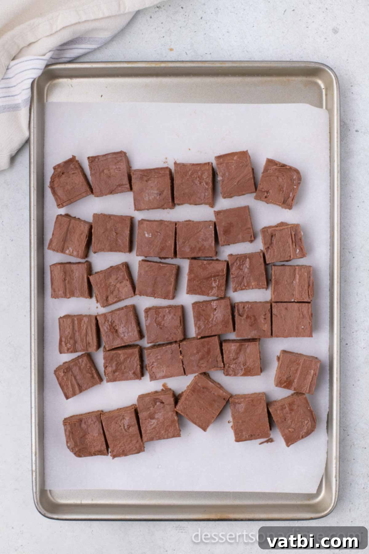 Cut chocolate squares placed on a baking sheet lined with wax paper, ready for further freezing.