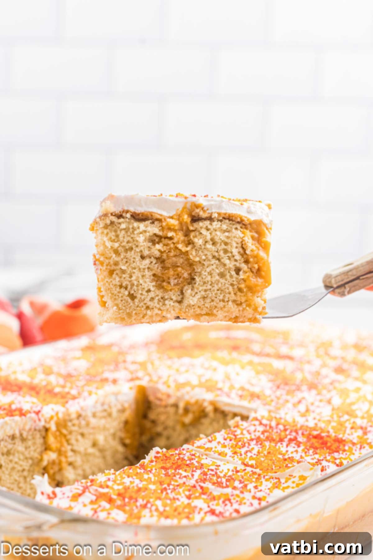 Cinnamon Whiskey Poke Cake 10 A serving of Fireball Poke Cake being carefully lifted from the pan with a spatula, ready to be enjoyed.