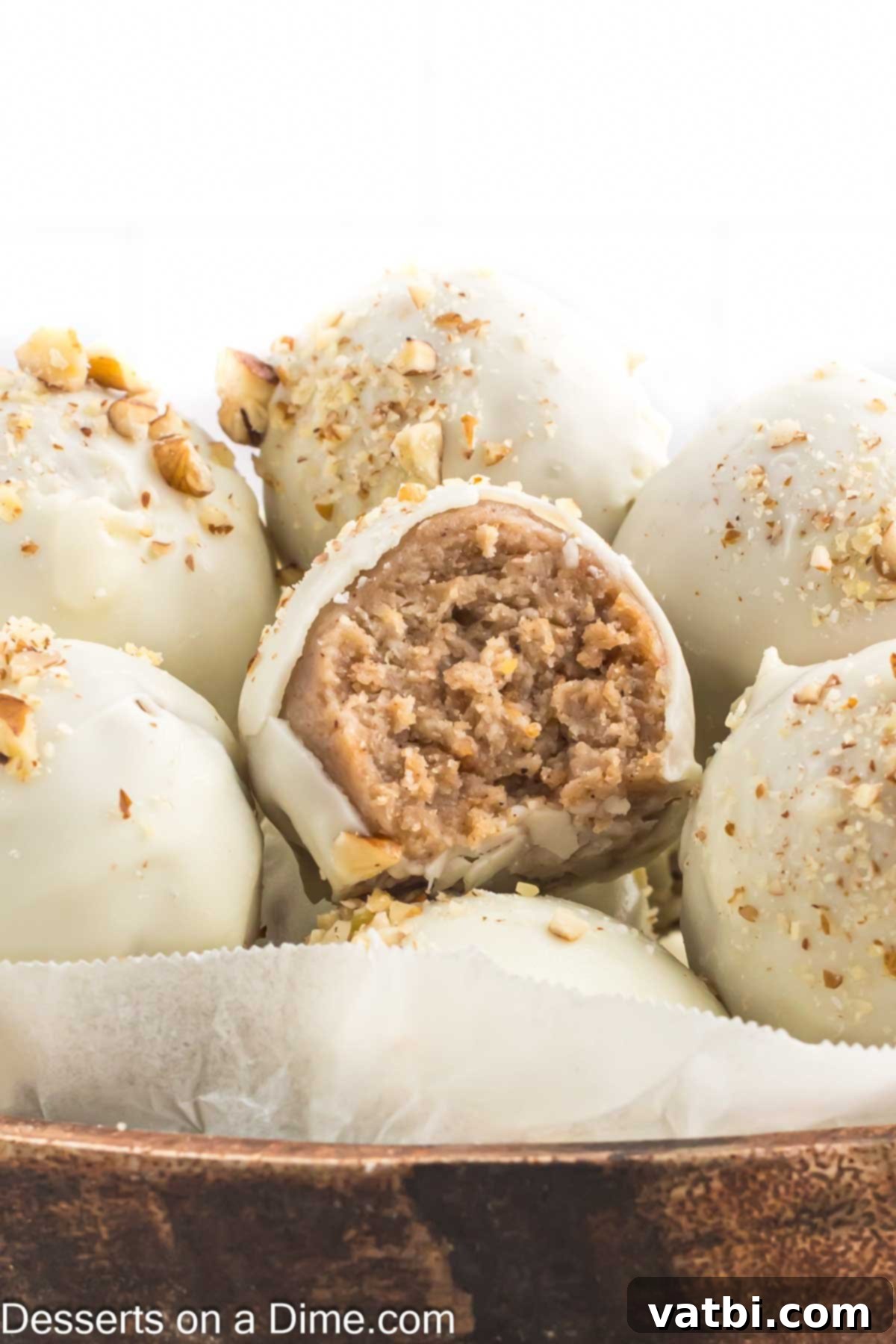 Spiced Carrot Cake Bites 2 A bowl filled with beautifully arranged Carrot Cake Truffles, showcasing their smooth chocolate coating and a sprinkle of chopped pecans.