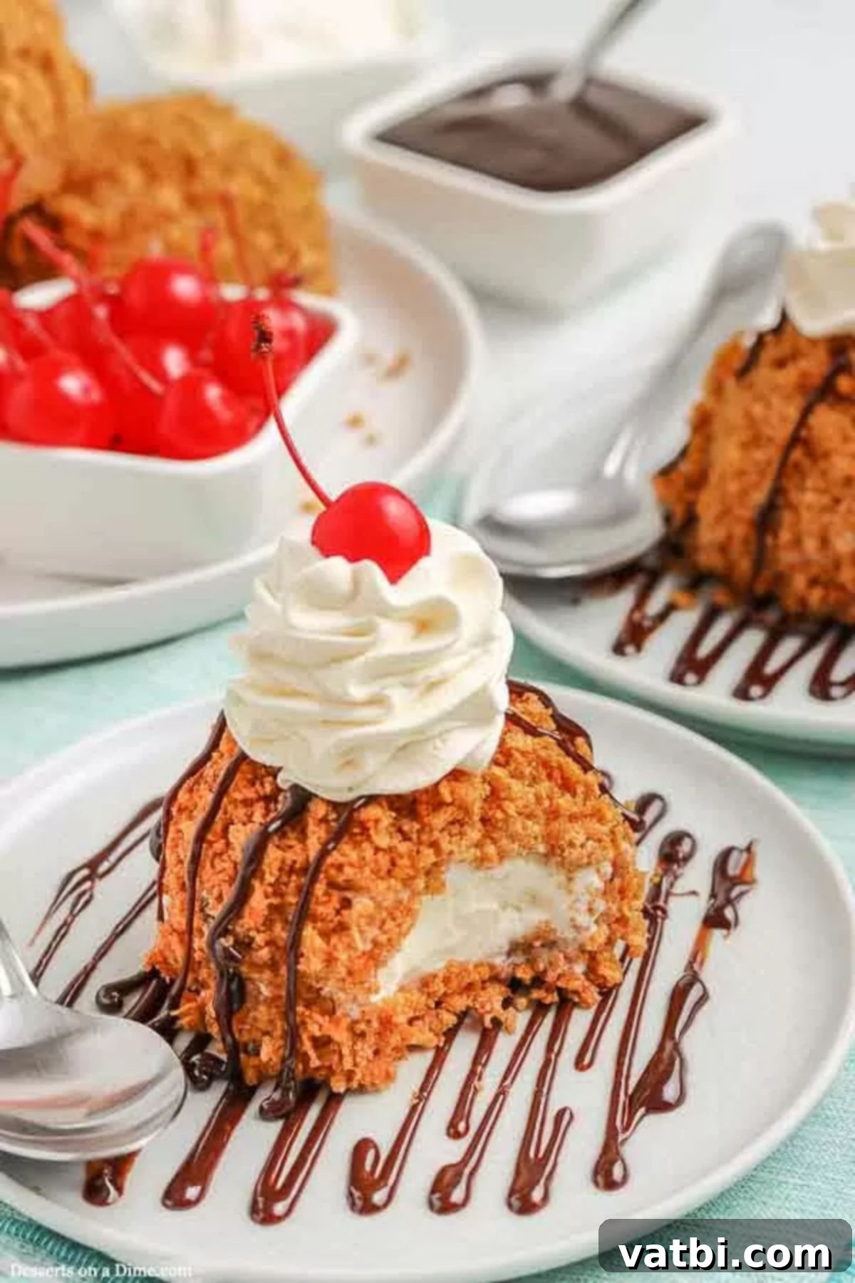 Enjoy deep fried ice cream recipe at home with this recipe. The crispy outside and the creamy ice cream combine for a restaurant style treat. Deep Fried Ice Cream on a white plate topped with whipped cream and cherries