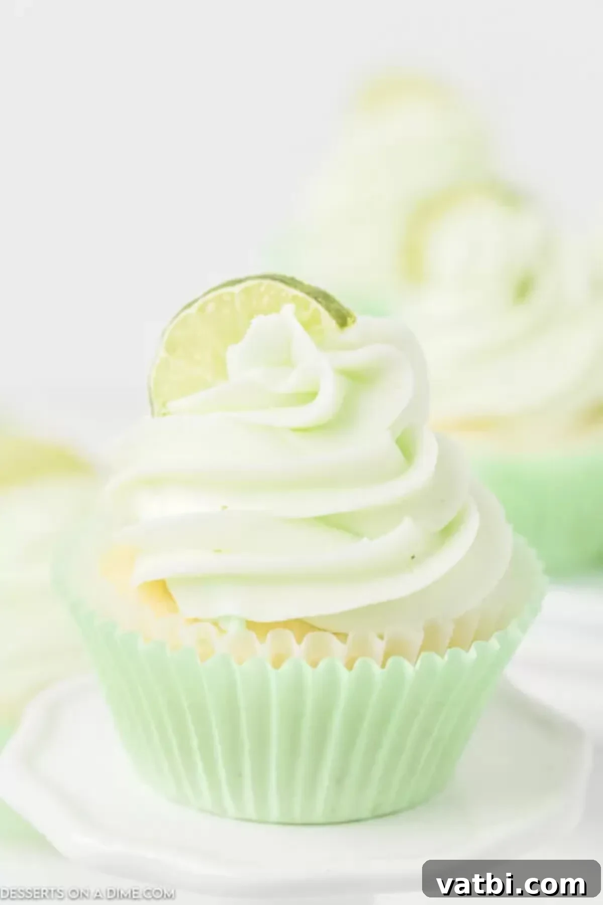 Sweet and tart key lime cupcakes make the best treat. Fans of key lime pie will love this recipe and the icing makes it even better. Try it! Key Lime Cupcakes topped with frosting and a slice of lime