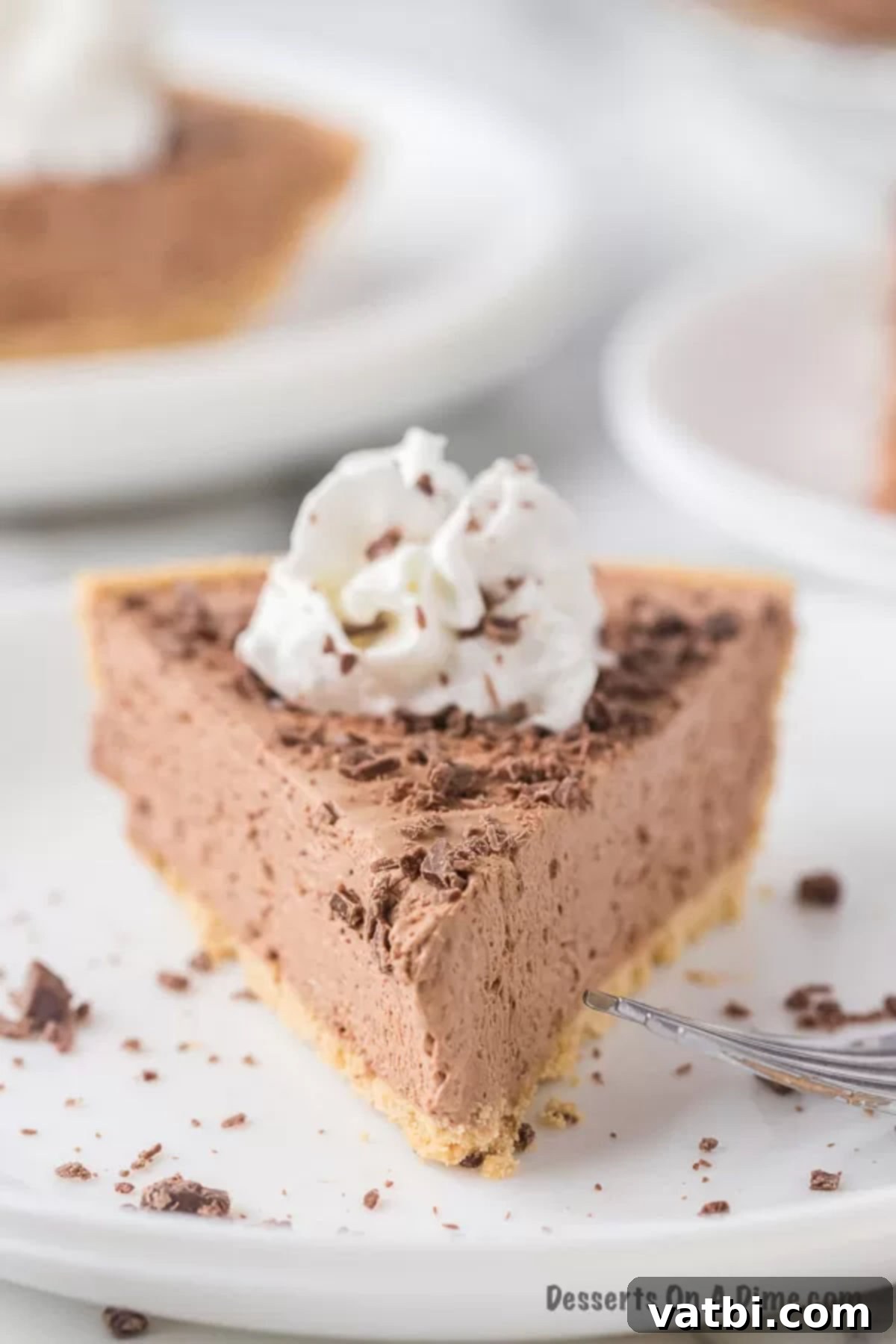 Slice of No Bake Hershey Pie on a plate, showcasing its creamy, light texture and chocolatey layers, garnished with chocolate shavings.
