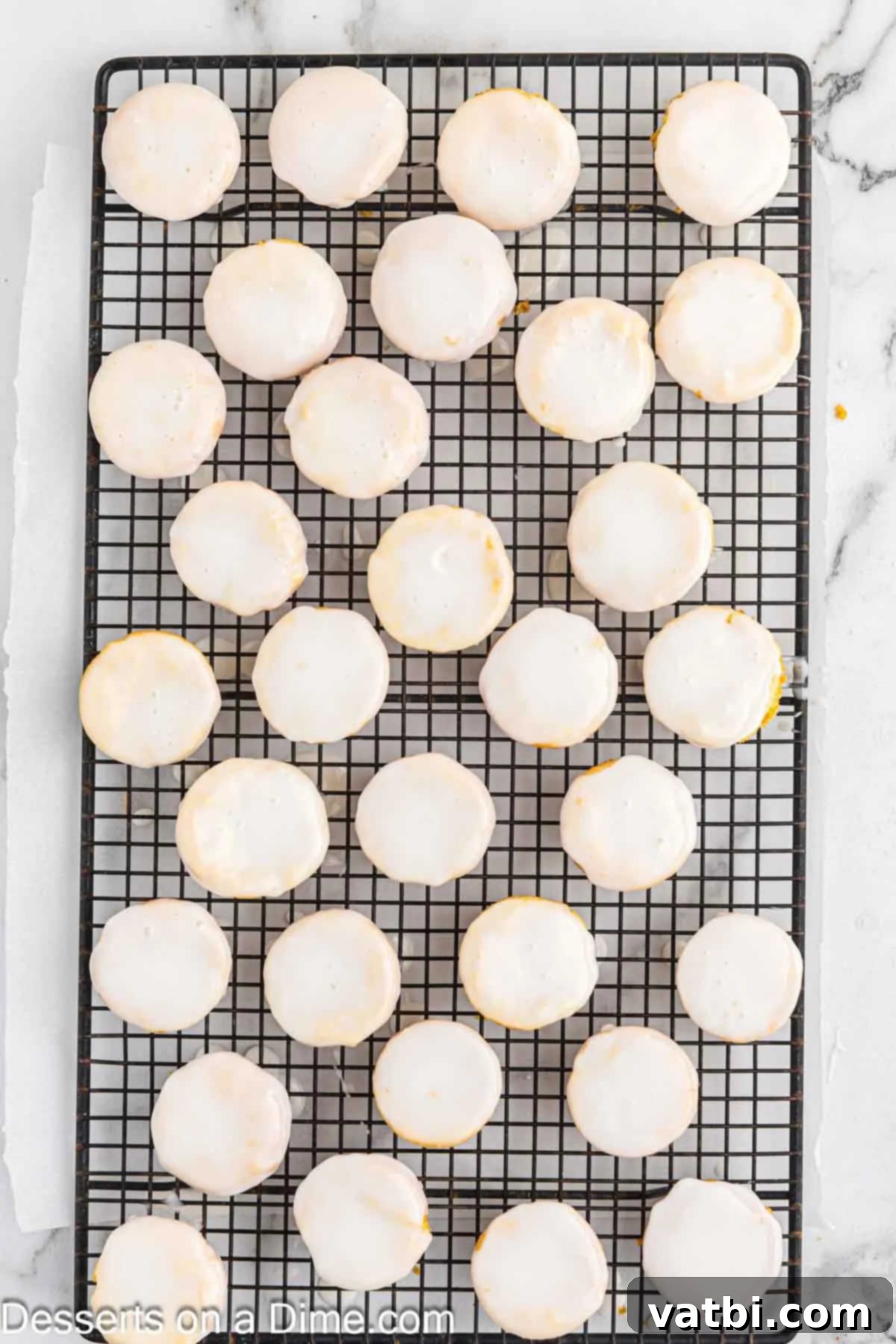 Dipping a warm Lemon Blossom into the freshly prepared lemon glaze.