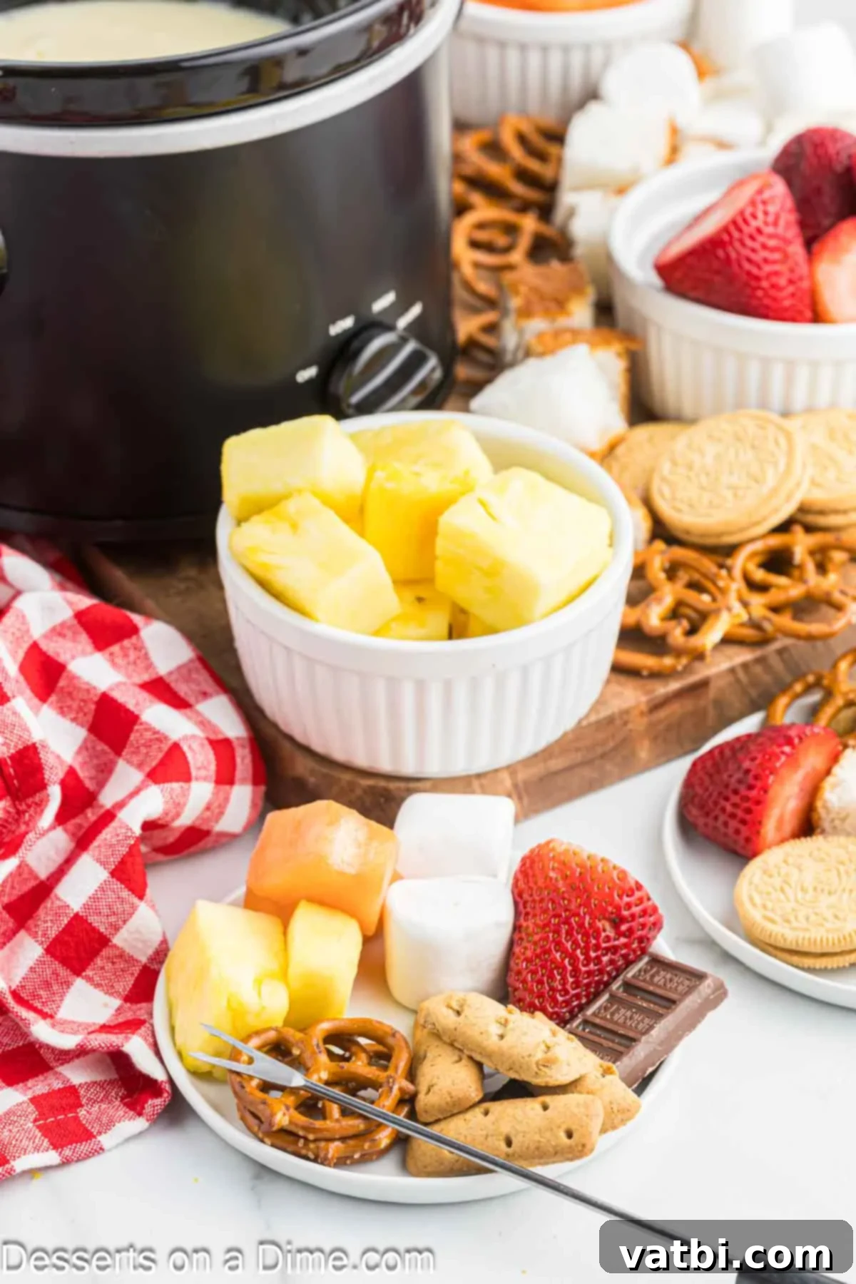 Decadent White Chocolate Fondue 6 A selection of dippers including fruit, marshmallows, and pretzels arranged on a platter.