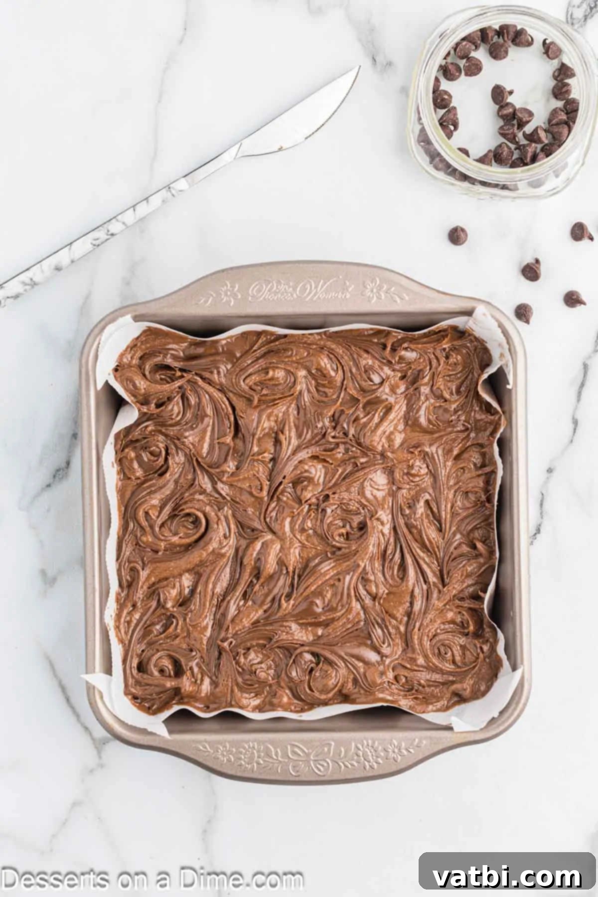 Fudgy Nutella Brownies 10 Brownie batter with Nutella drops being swirled with a butter knife to create an elegant marble effect before baking.
