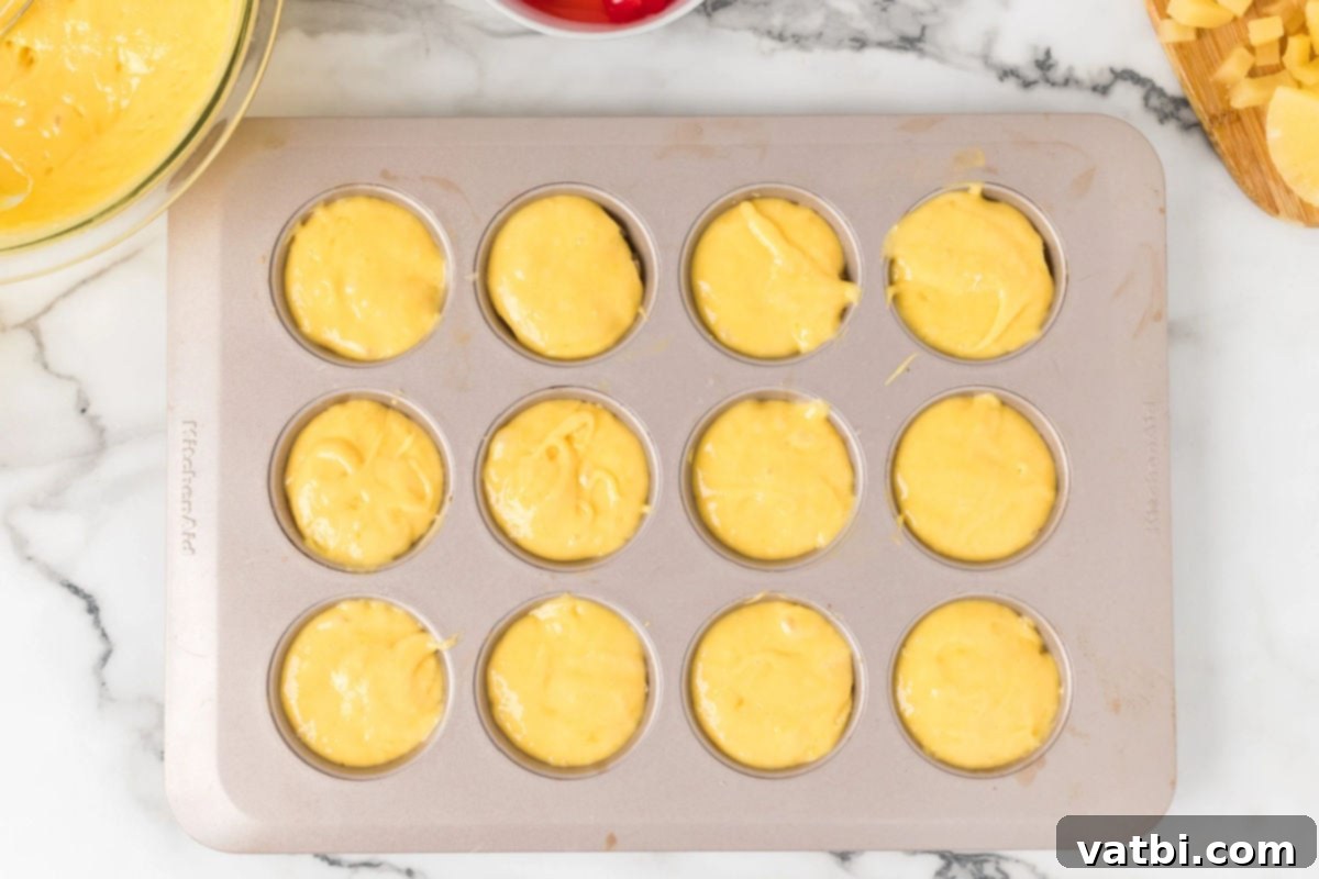 Caramel Pineapple Crown Cupcakes 8 Batter on top of muffin tin.