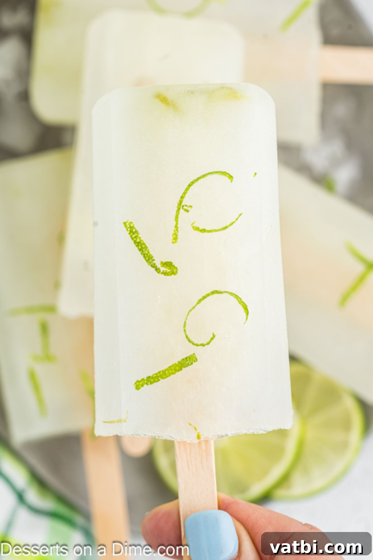 Enjoy light and refreshing lime popsicles when you make this recipe. It is the perfect summer time treat and the entire family will enjoy. Several homemade lime popsicles, vibrant green and perfectly frozen, arranged in a visually appealing way.