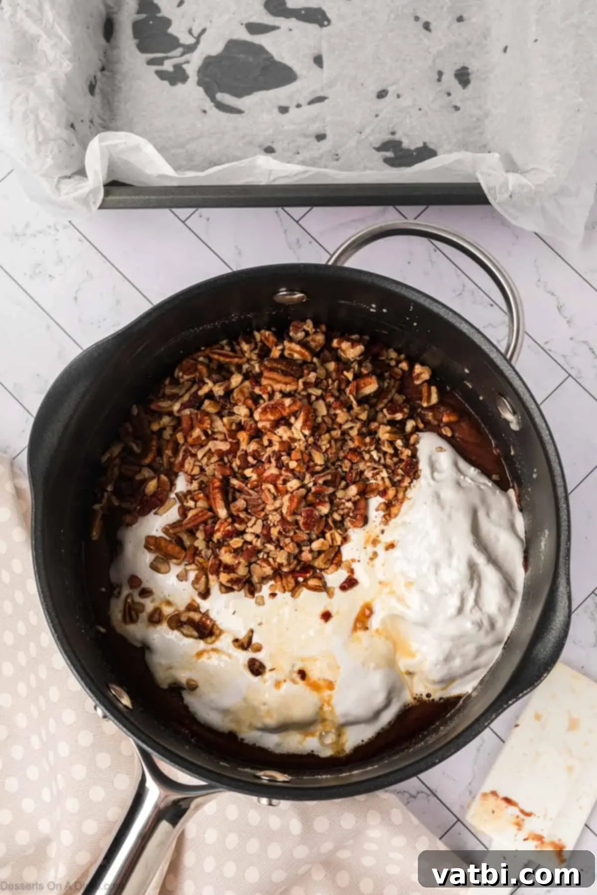 Marshmallow fluff and pecans in mixture.