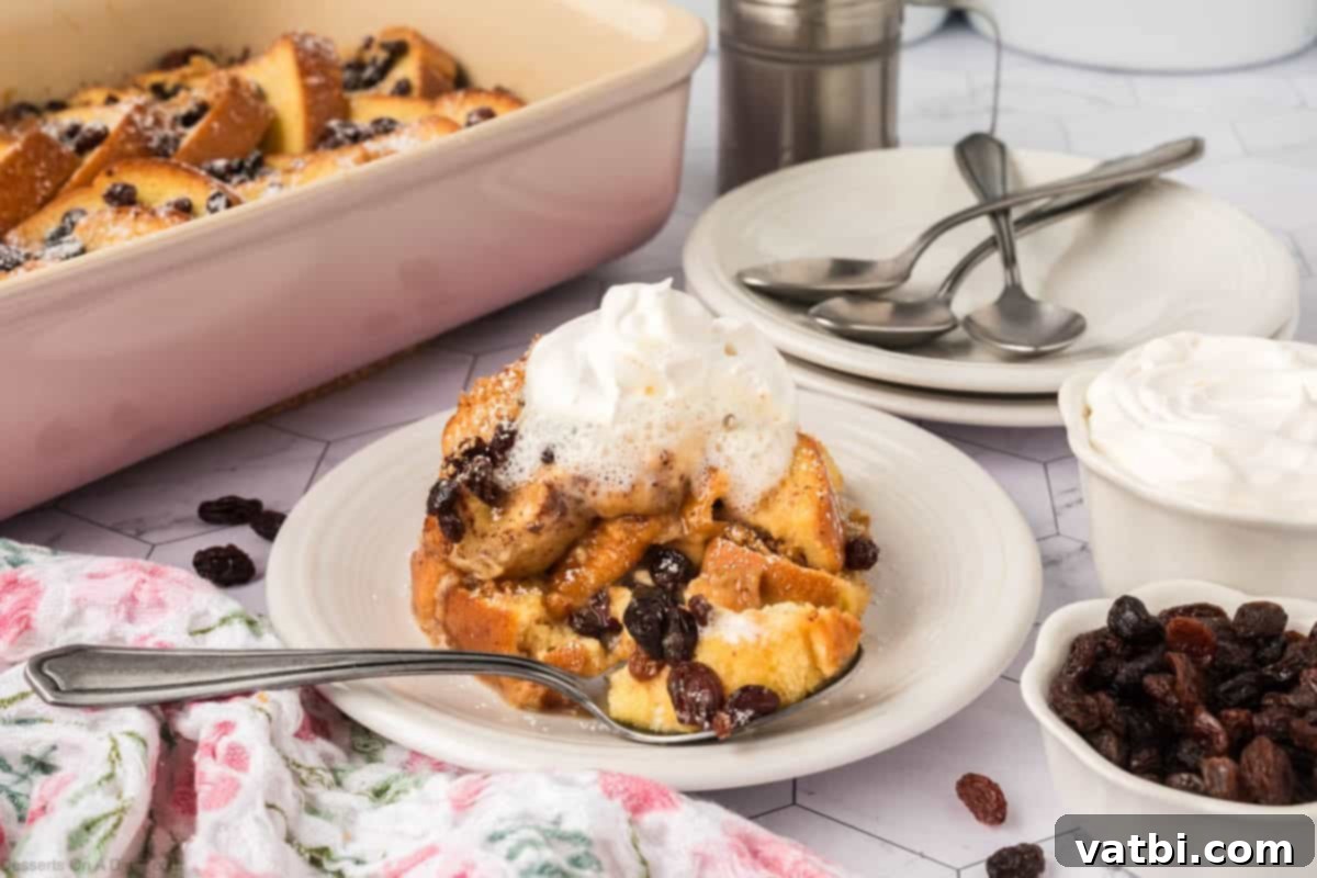 A delectable bread pudding served on a white plate, generously topped with fresh whipped cream and a sprinkle of cinnamon, ready to be enjoyed.