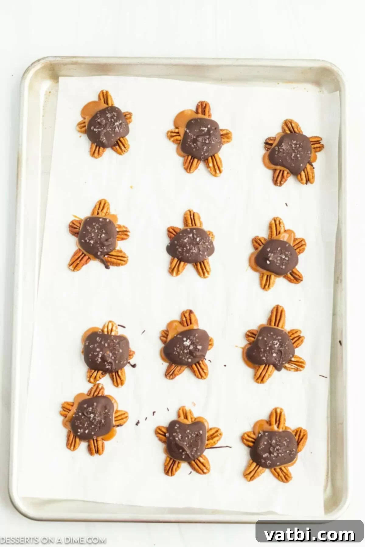 Melted chocolate covering the caramel and pecans, with a sprinkle of sea salt on top.