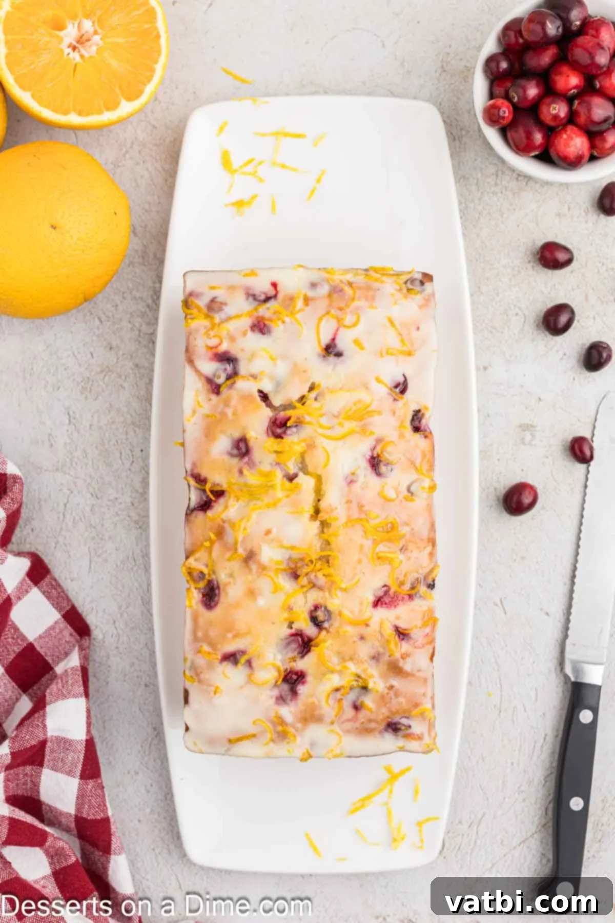 Zesty Orange Cranberry Loaf 9 Orange glaze being drizzled over the cooled orange cranberry bread.