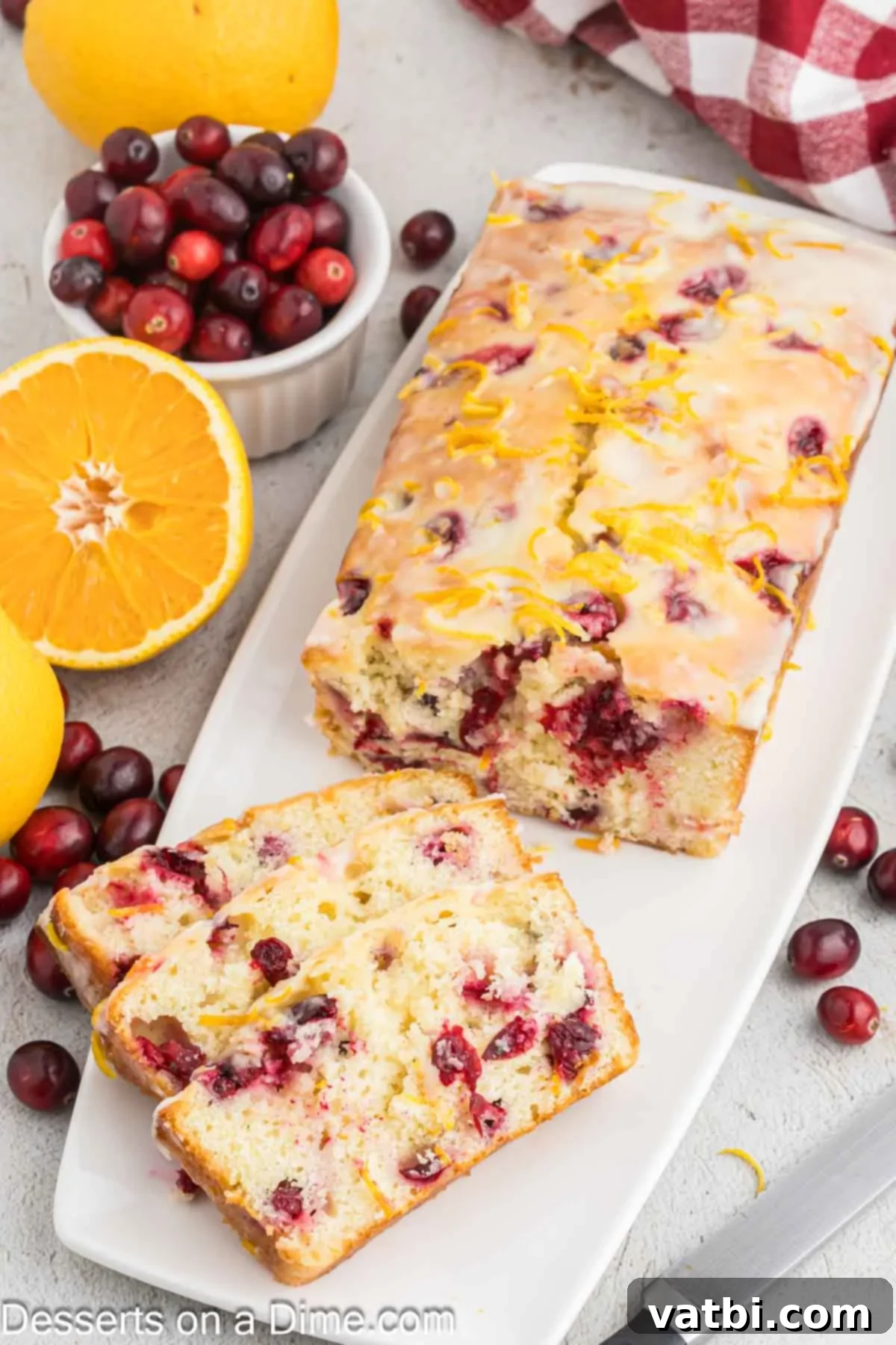 Zesty Orange Cranberry Loaf 10 Slices of orange cranberry bread, showing the moist interior and vibrant cranberries, on a serving board.
