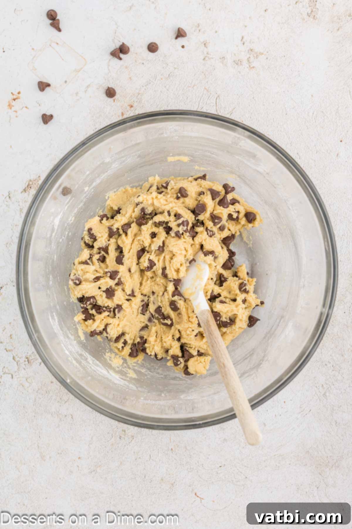 Chocolate chips being folded into the prepared cookie dough.